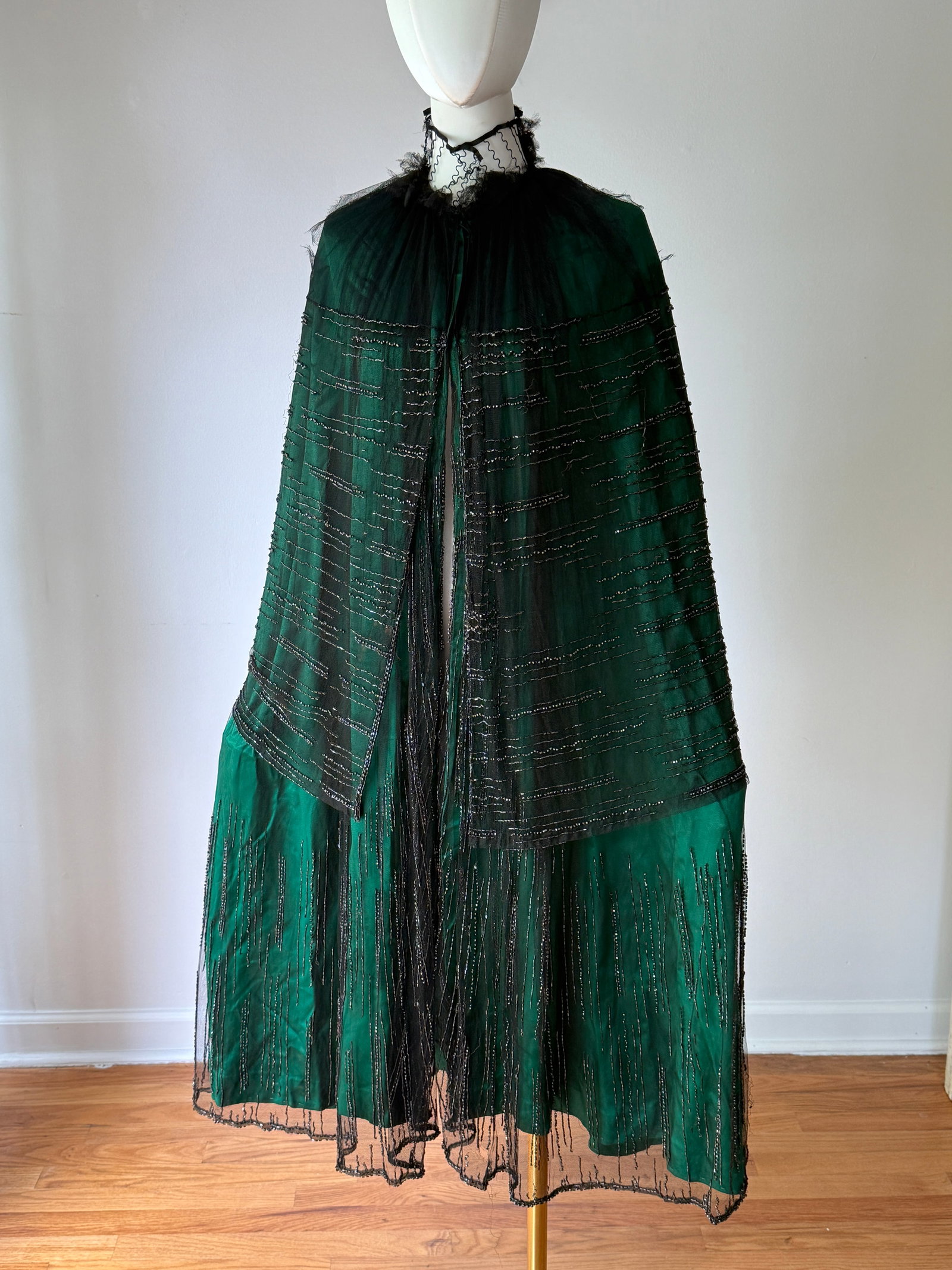 Antique 1910s 1920s Fancy Green Silk Beaded Tulle Opera Cape: Antique 1910s 1920s ladies cape by Rosenbaum & Company, Atlantic City. The cape is in a luxurious green silk covered in black tulle and adorned with intricate glass crystal beading throughout. The cap