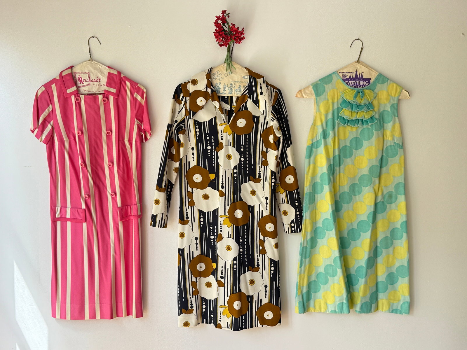 Three Vintage 60s Mod Mid Century Dresses: Group of three mid century dresses- pink and white striped short sleeved dress with a double breasted button front and pockets. A long sleeved shift dress in black and white floral motif, and a sleeve