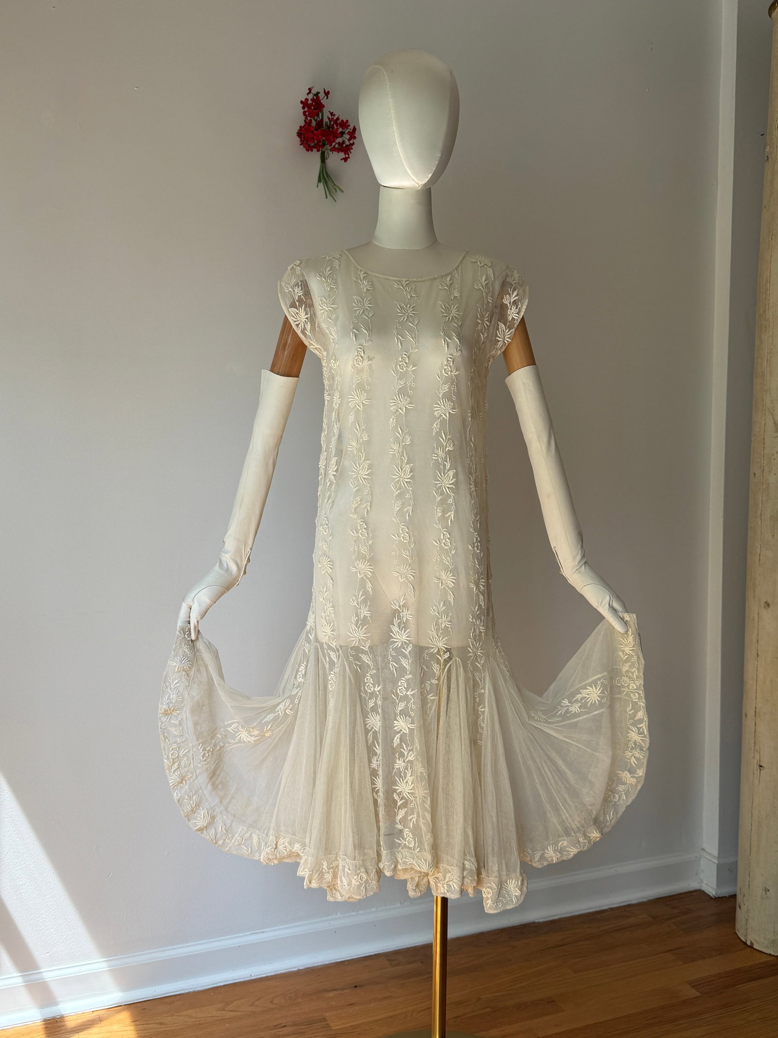 Vintage 1920s Handmade Lace Dress with Ruffle Skirt: Antique 1920s dress in ivory lace with dropped waist silhouette. Vertical bands of floral and vine embroidery decorate the length of the torso and upper skirt panel. The garment includes short cap sle