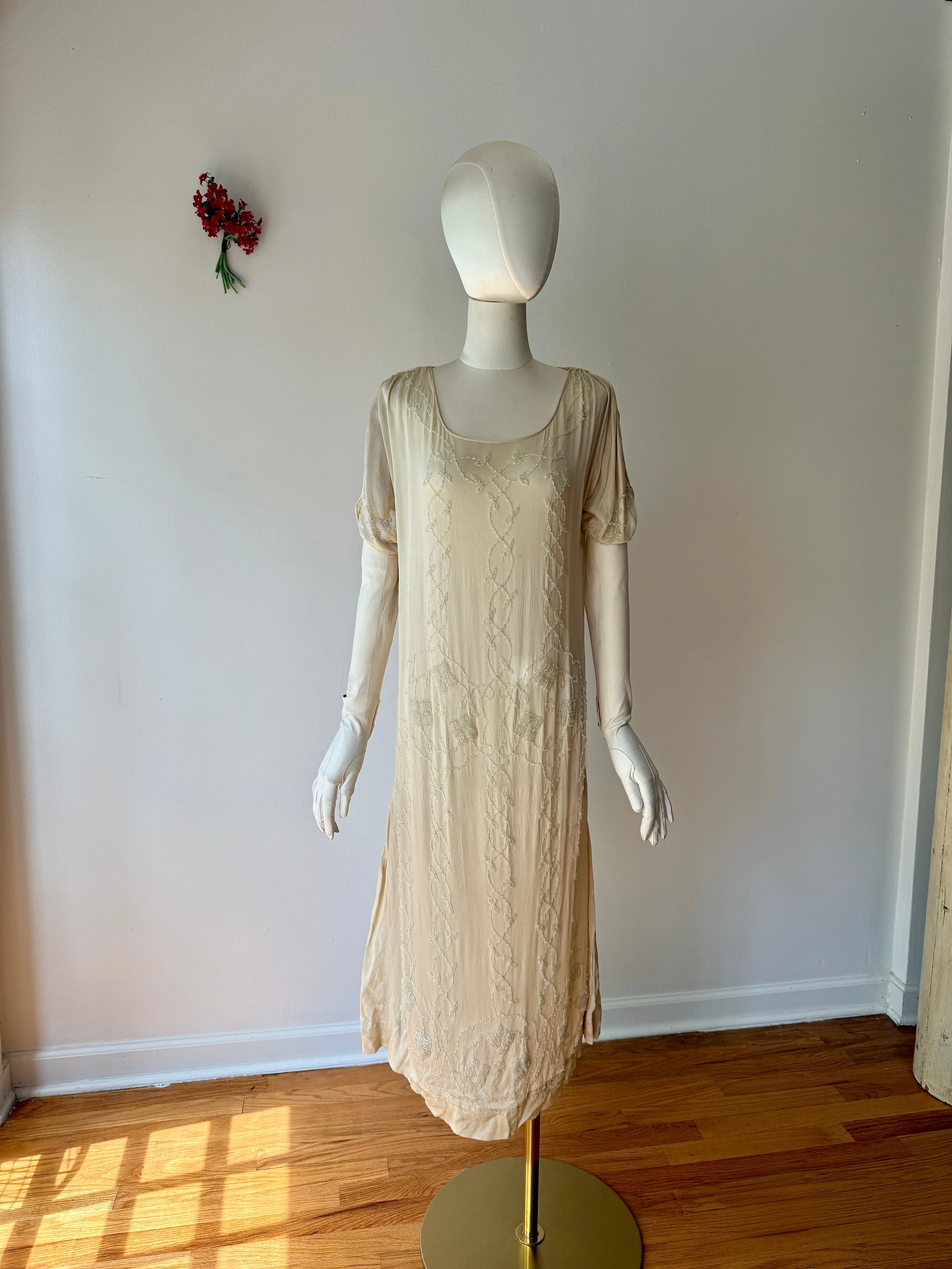 Antique 1920s Deco Glass Beaded Ivory Silk Crepe Flapper Dress: Antique 1920s dress in a cream silk crepe with elaborate glass beadwork in a Art Deco motif. Scrolling vines and geometric patterns that traverse the length of the garment, hand beaded with shimmering