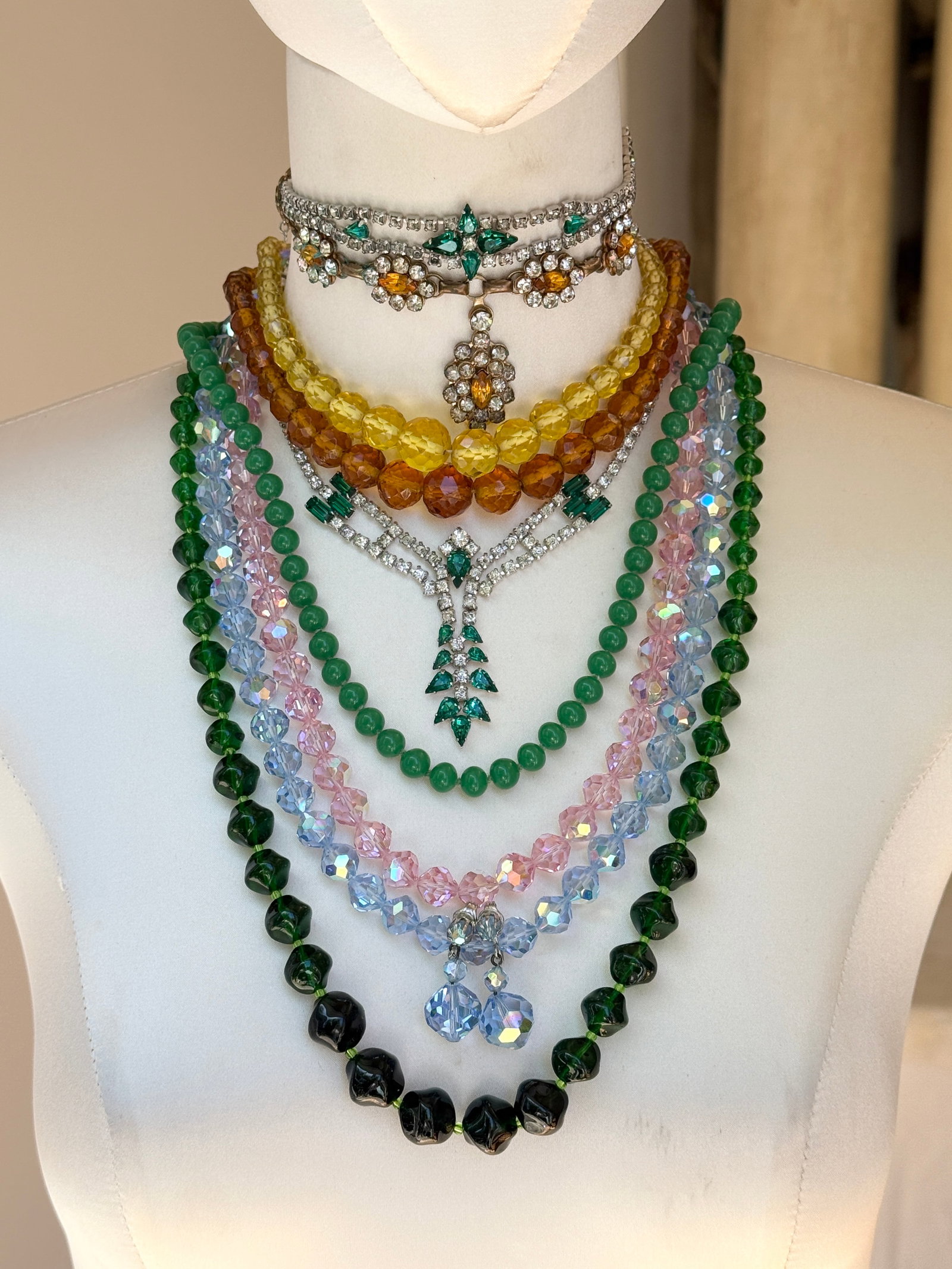 Vintage Rhinestone Art Glass Necklaces Costume Jewelry Collection: Assortment of vintage costume jewelry includes several strands of faceted art glass beads in pretty shades of emerald green, soft pink, amber, and canary yellow, along with a delicate pale blue irides