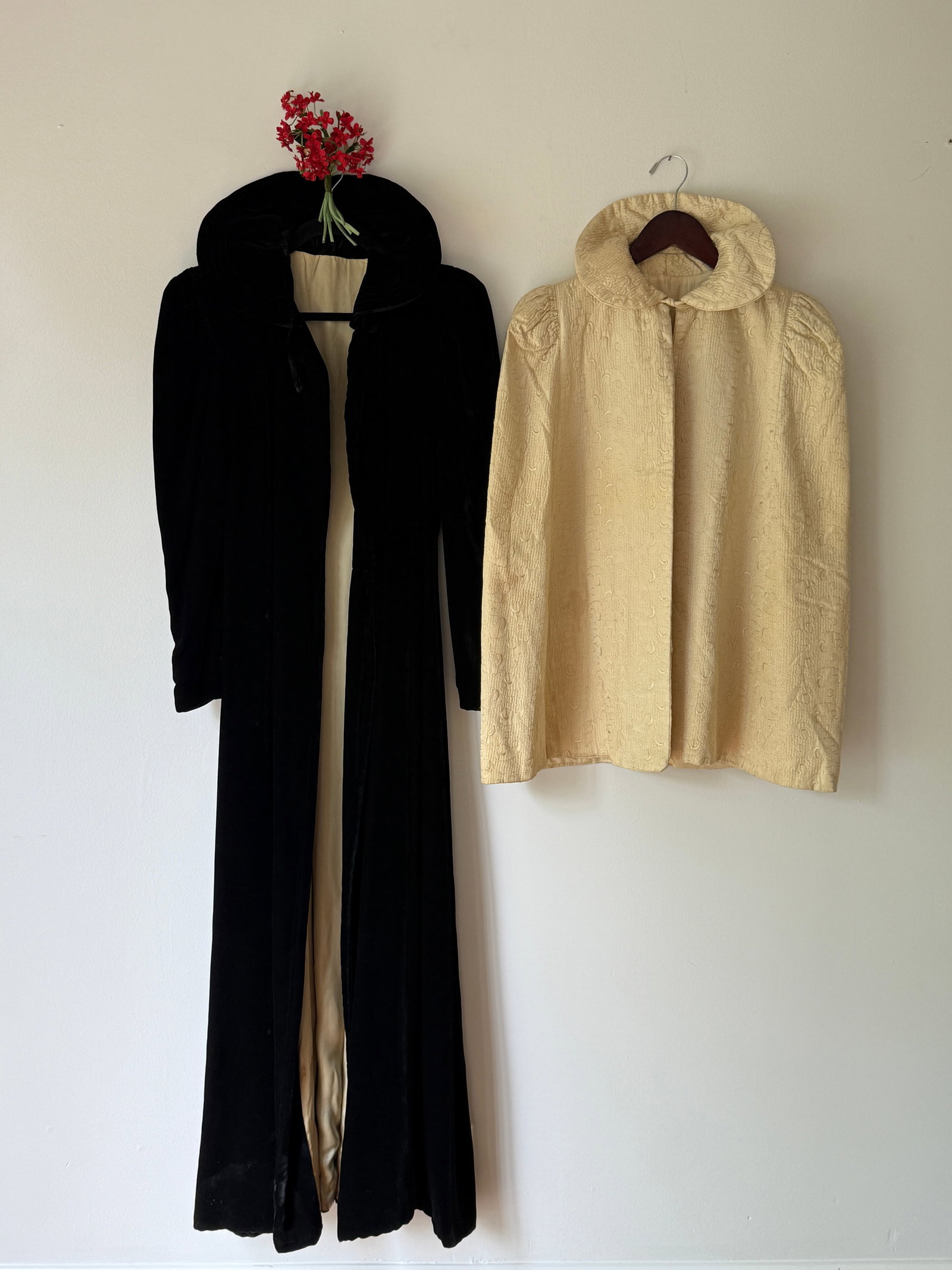 Two Vintage 1930s 40s Evening Coats Black Velvet and Cream Brocade Cape: This lot features two pieces of early mid century evening outerwear. The first is a full length 1930s black velvet opera coat with structured padded shoulders and lined in an ivory satin. Measurements