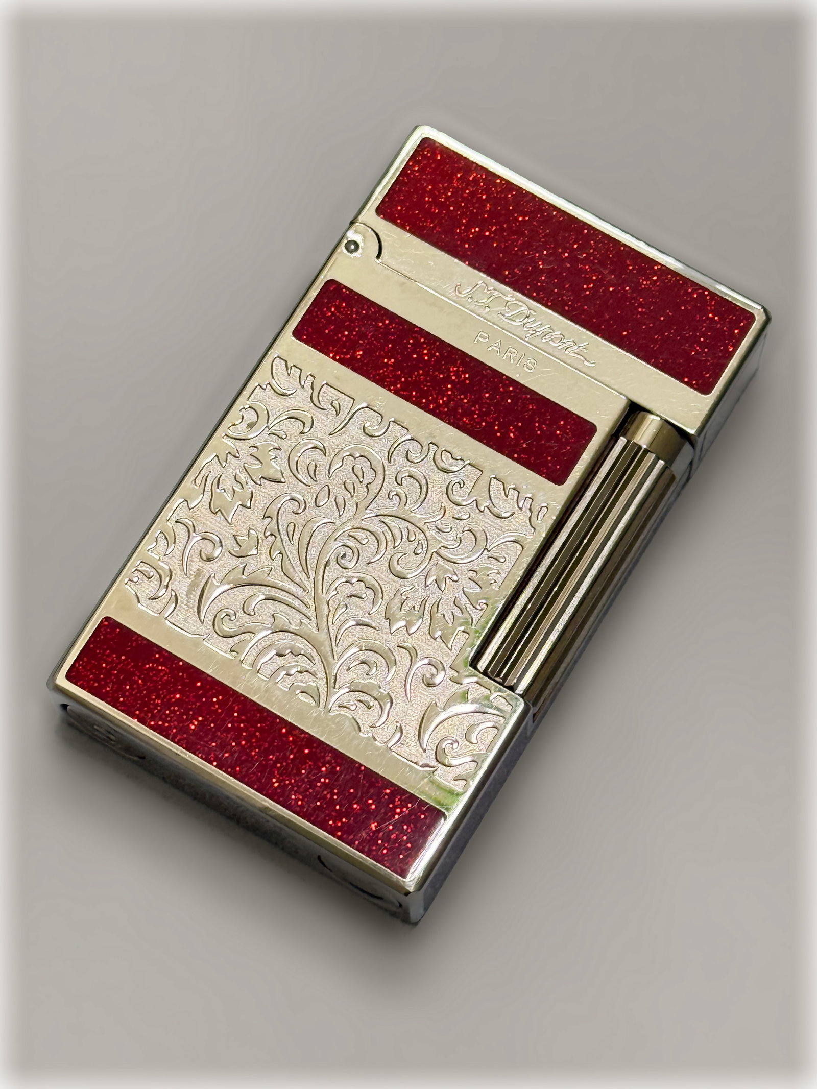 Vintage S.T. Dupont Paris Lighter Silver Engraved Floral Arabesque Red Enamel: S.T. Dupont Ligne 2 pocket lighter with wonderful engraved floral arabesque and leaf motif over a textured background, while the upper and lower perimeter sections are accented with inlaid panels of s
