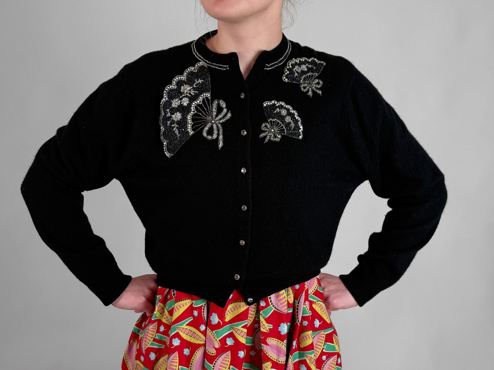 Vintage Embroidered Cashmere Wool Cardigan w/ Hand Fans: A vintage mid century black knit cardigan sweater featuring glass beadwork in the form of three hand fans detailed with clear, silver, and black micro beads, floral embroidery, and dimensional ribbon 