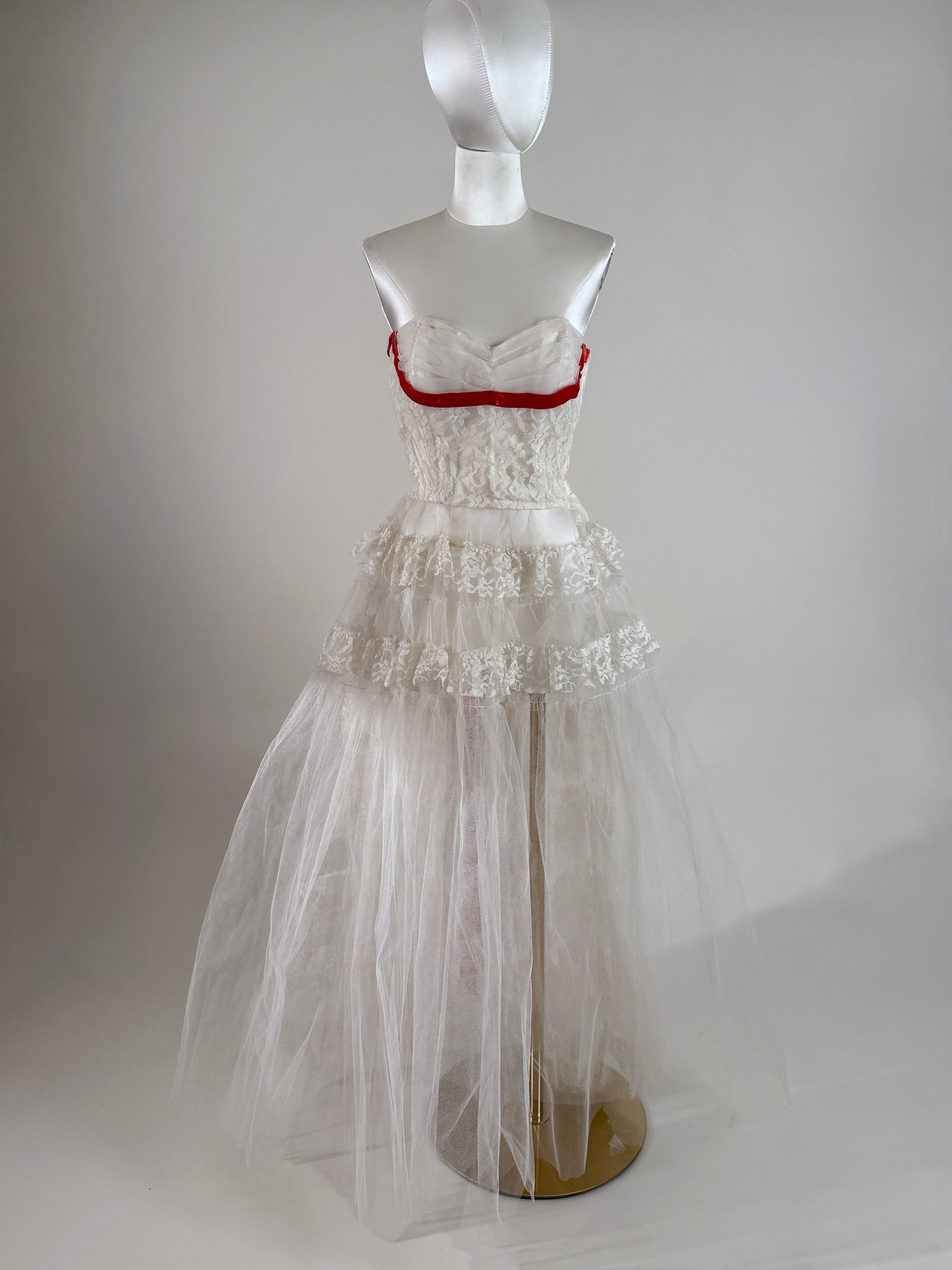 Vintage 1950s Strapless Tulle Lace Fancy Dress Red Velvet Ribbon: 1950s fancy dress featuring a strapless sweetheart bodice in white tulle and layers of scalloped floral lace. Crimson red velvet ribbon trim. The voluminous skirt drops into layered, tiered lace detai