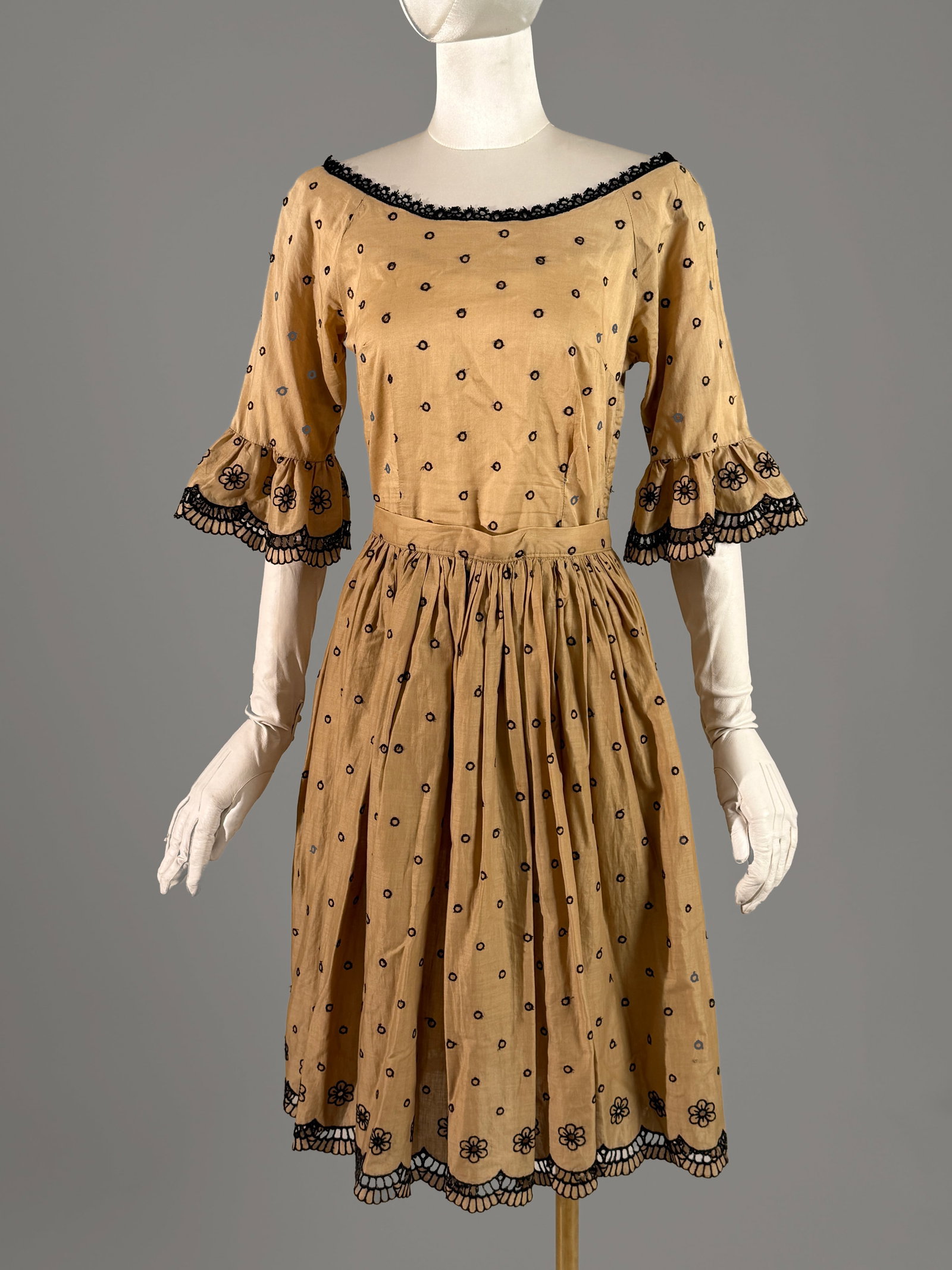 Vintage Linen Dress Set with Black Dot and Scalloped Eyelet Embroidery: A vintage two piece coordinated set comprising a tailored top and a matching skirt in a tan cotton linen fabric. All over motif of small, embroidered black open circle dots, trimmed in black scalloped