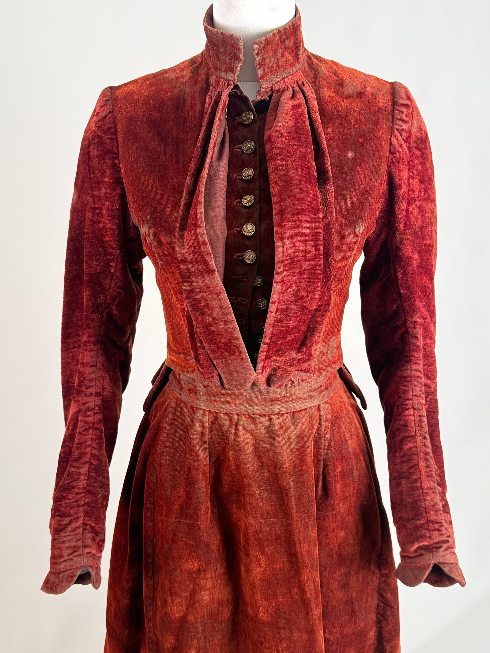 Antique Late 19th Century Burgundy Velvet Two Piece Walking Dress Ensemble: Antique Victorian era two piece ladies walking suit or day ensemble, comprising a tailored, structured bodice jacket and a coordinating floor length skirt. Heavy velvet pile with a distinct vertical w