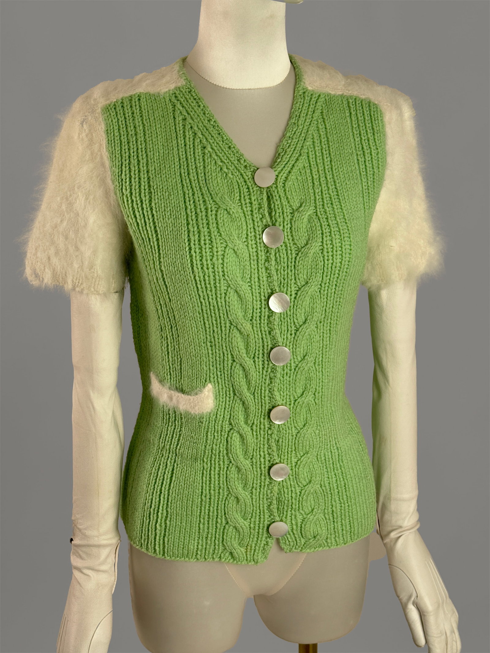 Vintage 1950s Lime Green Knit Cardigan Fluffy White Angora Mohair Sleeves: A vibrant and unique 1950s vintage short sleeved cardigan sweater top. The body is in a bright lime green ribbed wool knit, featuring a central cable knit pattern along the button placket and a single