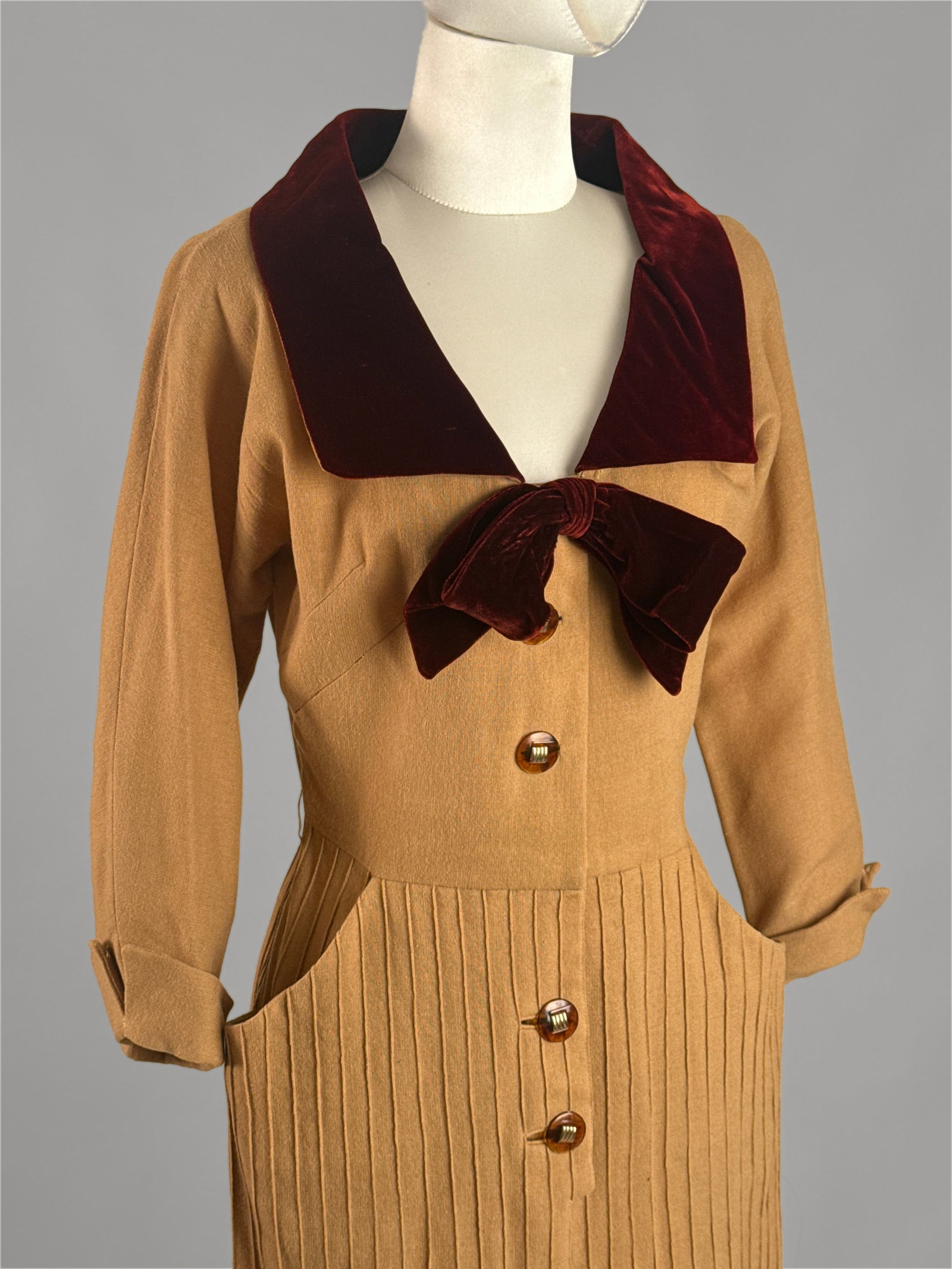 Vintage 1940s Wool Dress with Velvet Trim Bow: An elegant tailored 1940s wartime era dress in a tan lightweight wool and velvet accents along the collar, cuffs, and bodice detailing. Structural shoulders, a cinched waistline, and A line skirt. Dec