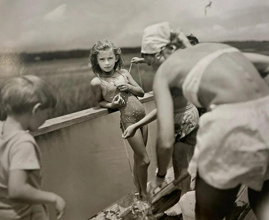 Sally Mann - Crabbing at Pawleys, 1989: SALLY MANN (B. 1951) Crabbing at Pawleys, 1989 Print in Colors 9 3/4" x 8 1/4" Sally Mann is an American photographer known for her black-and-white portraits of her family and documentation of the lan
