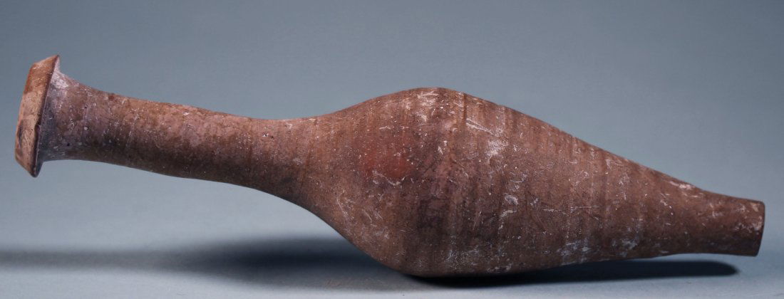 ROMAN POTTERY BOTTLE: An ancient Roman pottery bottle with a long, slender neck and tapering body. Ca. 1st - 2nd century AD. Height: 7 5/8 in. (19.5 cm.). Formerly in a Connecticut private collection.