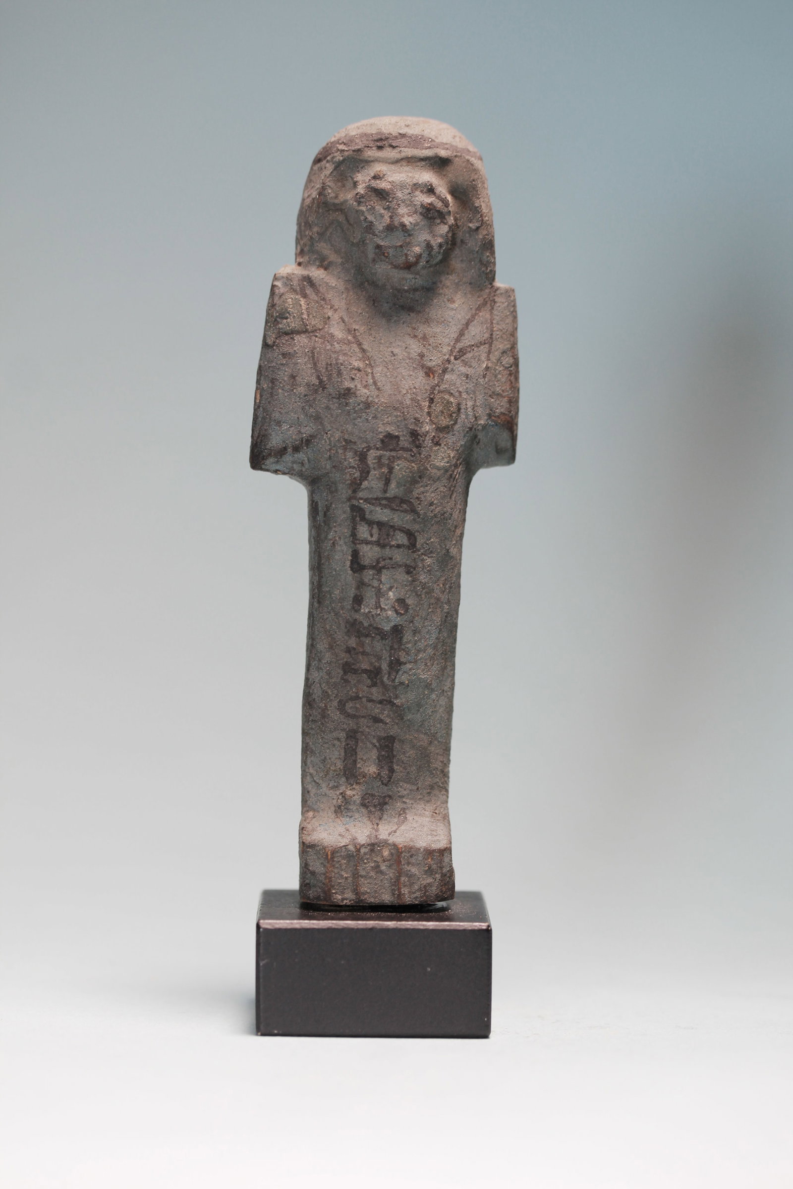 Egyptian Wood Shabti: An ancient Egyptian wood shabti, the mummiform figure painted blue with a agricultural implements, seed bag and vertical Hieroglyphic text in black ink. New Kingdom,Ca. 1570 - 1070 BC.Height: 4 in. (1