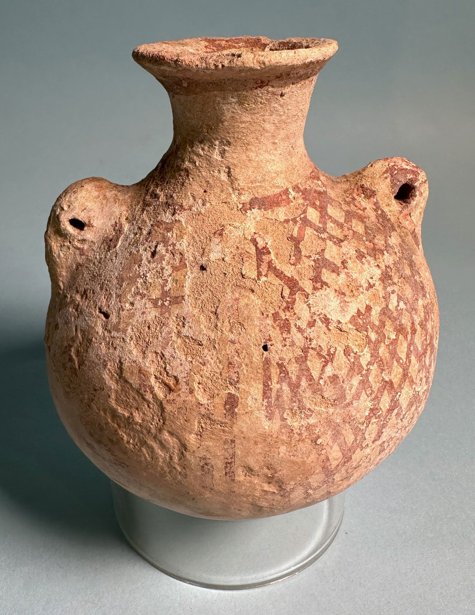 Judaean Pottery Vessel: An ancient Judaean globular lug handled pottery vessel painted with a cross-hatched pattern.The Levant.Ca. 1500 - 1000 BC.Height: 4 1/4 in. (10.8 cm).Formerly in a New Jersey private collection.