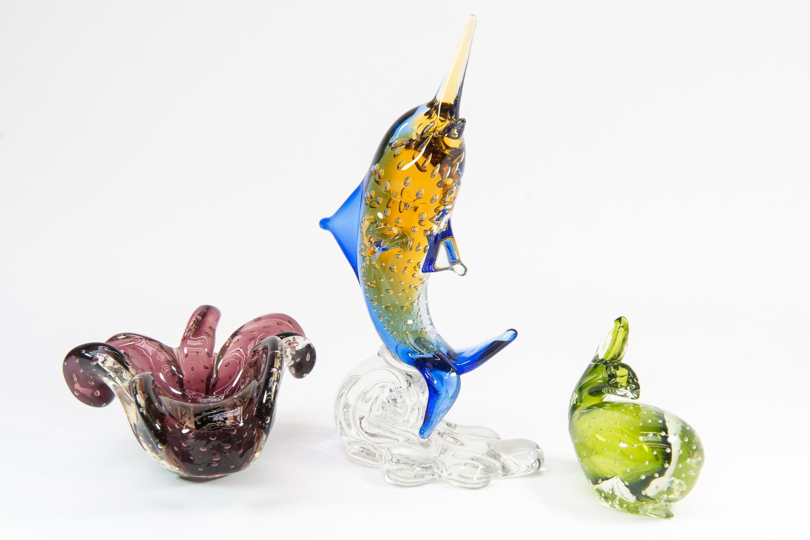 Bullicante Murano Glass Pieces: This lot features (3) Bullicante Murano Glass Pieces. Items include: Blown Purple Ashtray, Signed Icet Murano Swordfish, and a Green Whale Condition Good Condition