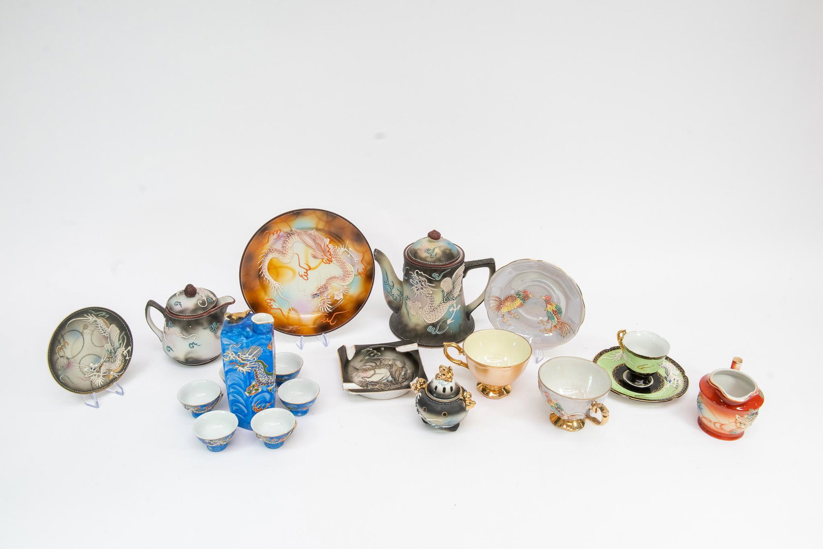 Hand Painted Japanese Assortment: This lot features a wide assortment of hand-painted Japanese ceramics. Most are signed and include teapots, ashtrays, vases, sake glasses, and more. Size Largest is 7''T 8''W Condition Various Conditi
