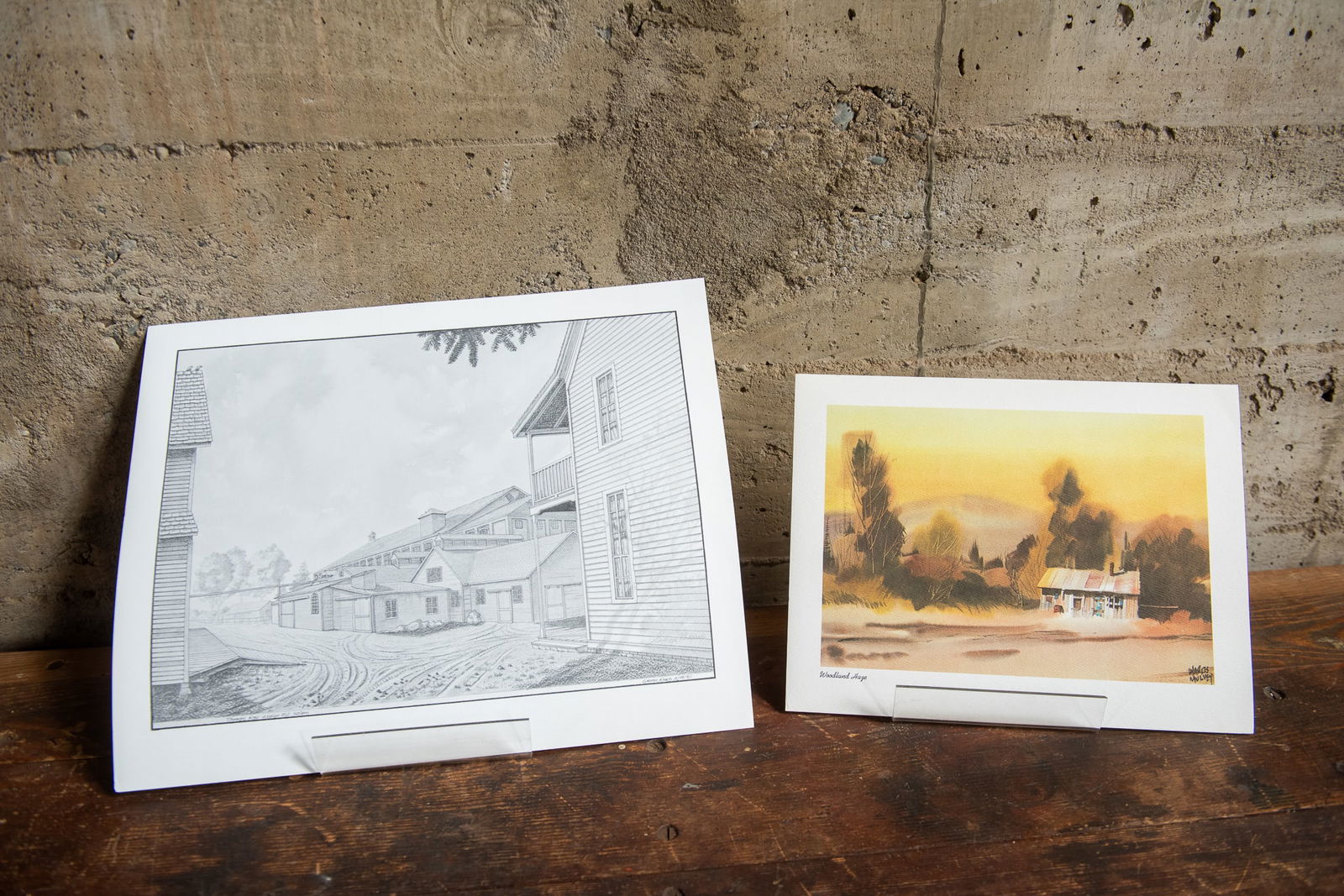 VINTAGE ARTWORK PRINTS BY GEORGE KRAUS & CHARLES MULVEY: Two vintage art prints, one titled, "Thomas Kay Woolen Mill, Salem" by George Kraus and the other titled, "Woodland Haze" by listed artist Charles Mulvey. Kept in protective covering. Size Largest 14'