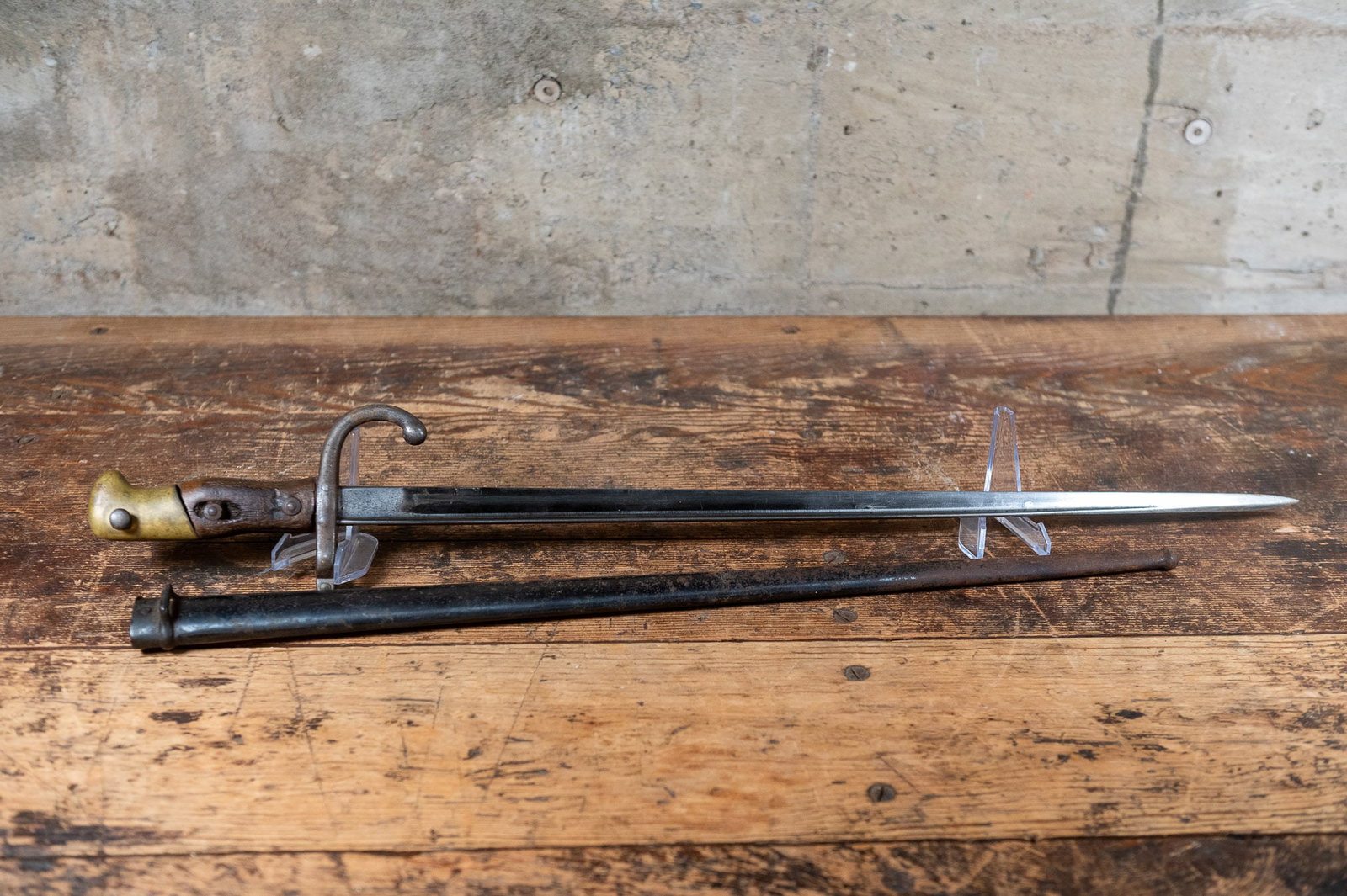 FRENCH MODEL 1874 'GRAS' SWORD BAYONET, 1877: A French Model 1874 "Gras" infantry rifle sword bayonet. Made in 1877. This bayonet has a solid brass pommel with integral latching mechanism, wood handle, and a steel crossguard with muzzle ring. The