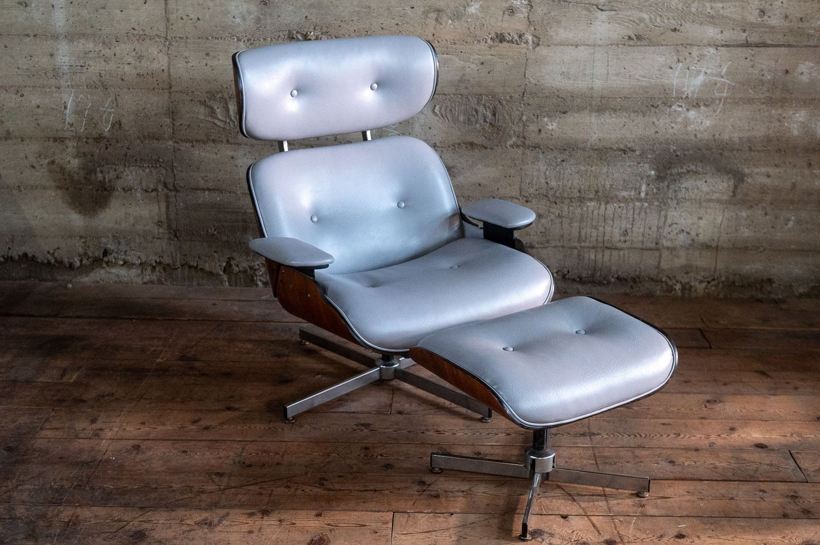 PLYCRAFT CHAIR & OTTOMAN: A stunning mid-century modern Plycraft chair and ottoman with wood frame and professionally upholstered with new gray colored leather. Chair measures 37.5'' H x 32'' W x 28'' D. Paul Goldman founded P