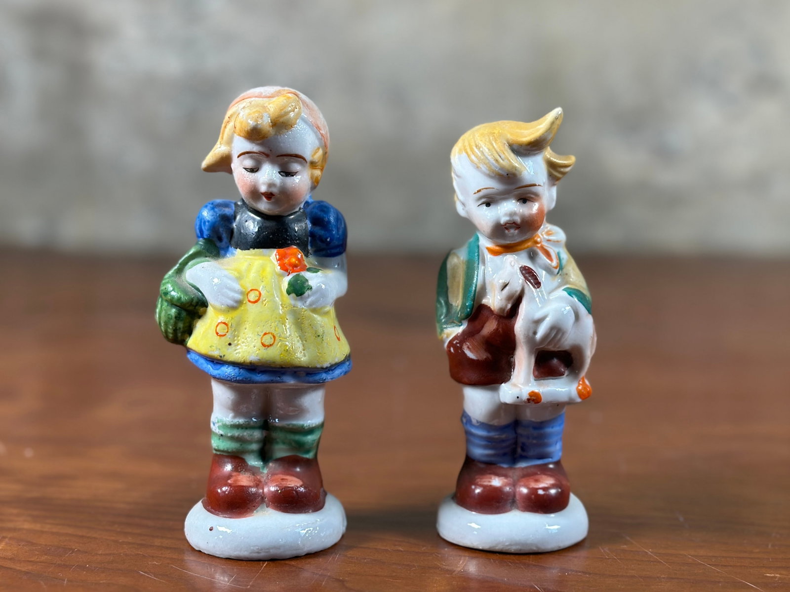GERMAN BOY & GIRL SALT AND PEPPER SHAKERS, OCCUPIED IN JAPAN: A pair of antique salt and pepper shakers depicting a German boy and girl. Both made in Occupied Japan and marked underneath as shown in photos. The tallest figure measures 4.5'' H x 2'' W x 2'' D.