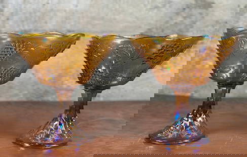 PAIR OF IRIDESCENT CARNIVAL GLASS WEDDING BOWLS: A pair of iridescent Carnival Glass wedding bowls, manufactured by Indiana Glass Company. Both are in very good condition. Each one measures, 8.5'' H x 8.25'' W x 8.25'' D. Indiana Glass Company had m