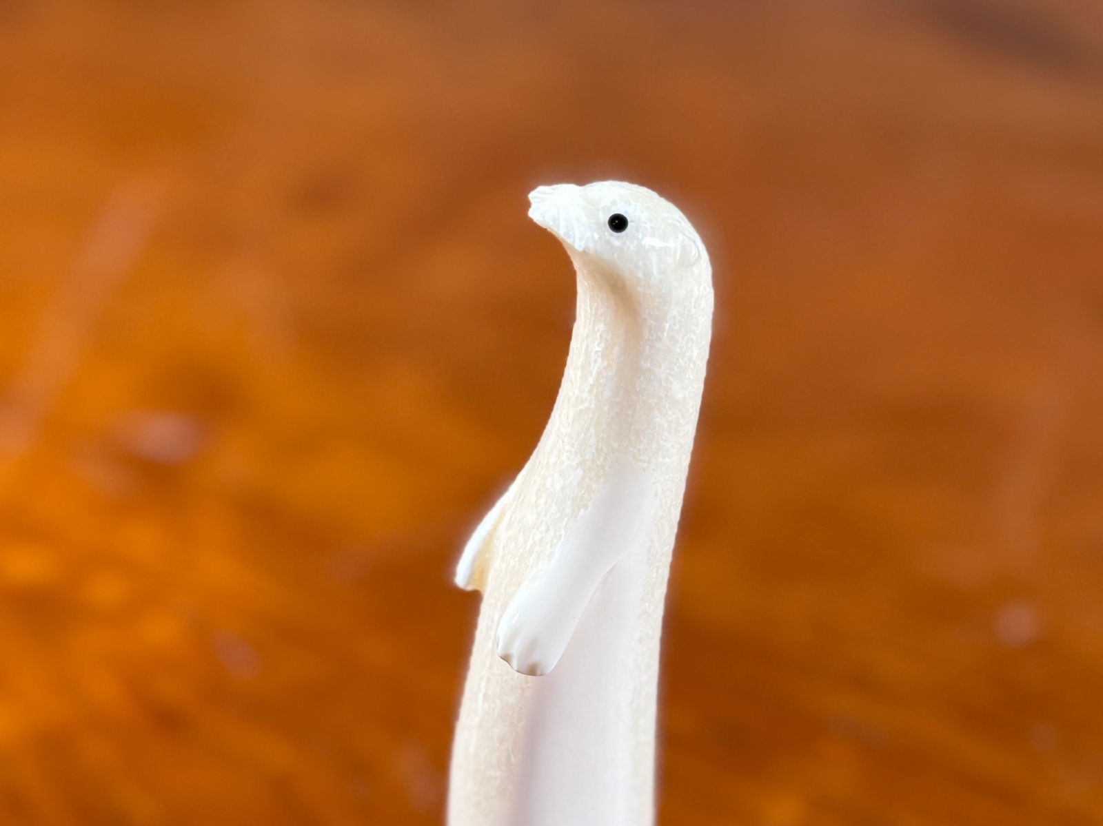 AARON OSEUK, STANDING OTTER BONE SCULPTURE: This lot features a standing Otter bone sculpture by listed artist, Aaron Oseuk. Signed underneath as shown in photos and dated 2005. This ivory sculpture measures, 5” H X 1” W X 2”