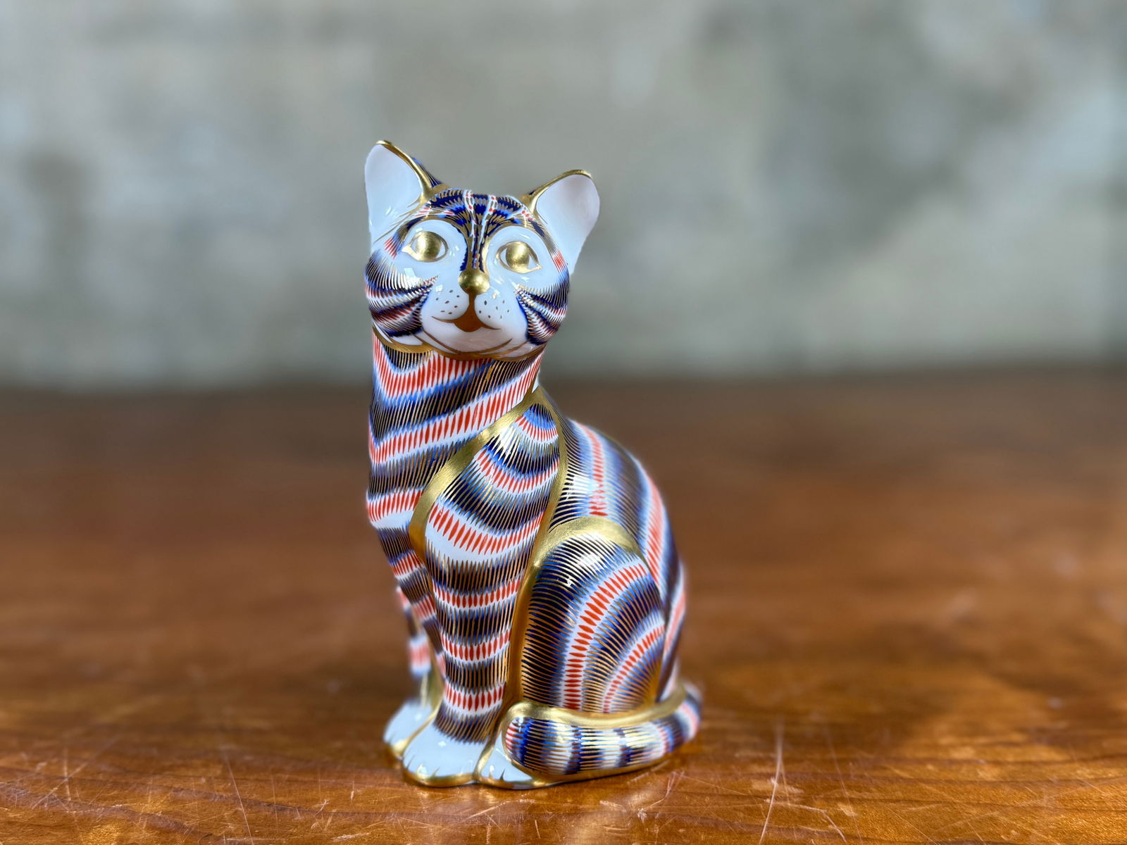 ROYAL CROWN DERBY IMARI CAT PAPERWEIGHT: This lot features a Royal Crown Derby Imari Cat paperweight, made in England with the traditional Imari pattern and 22-karat gold gilt accents on white bone china. Measures, 5'' H.
