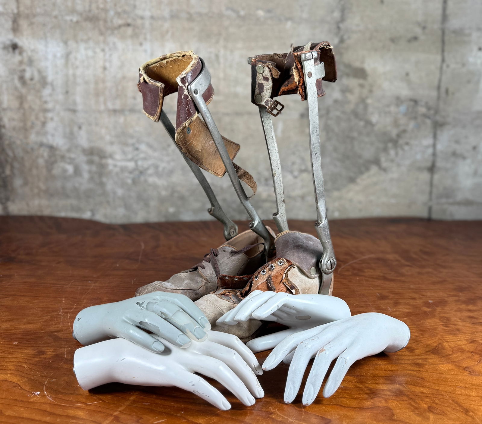 EARLY 20TH CENTURY LEG BRACES & MANNEQUIN HANDS: This lot features a pair of early 20th century leg braces and a collection of antique mannequin hands.