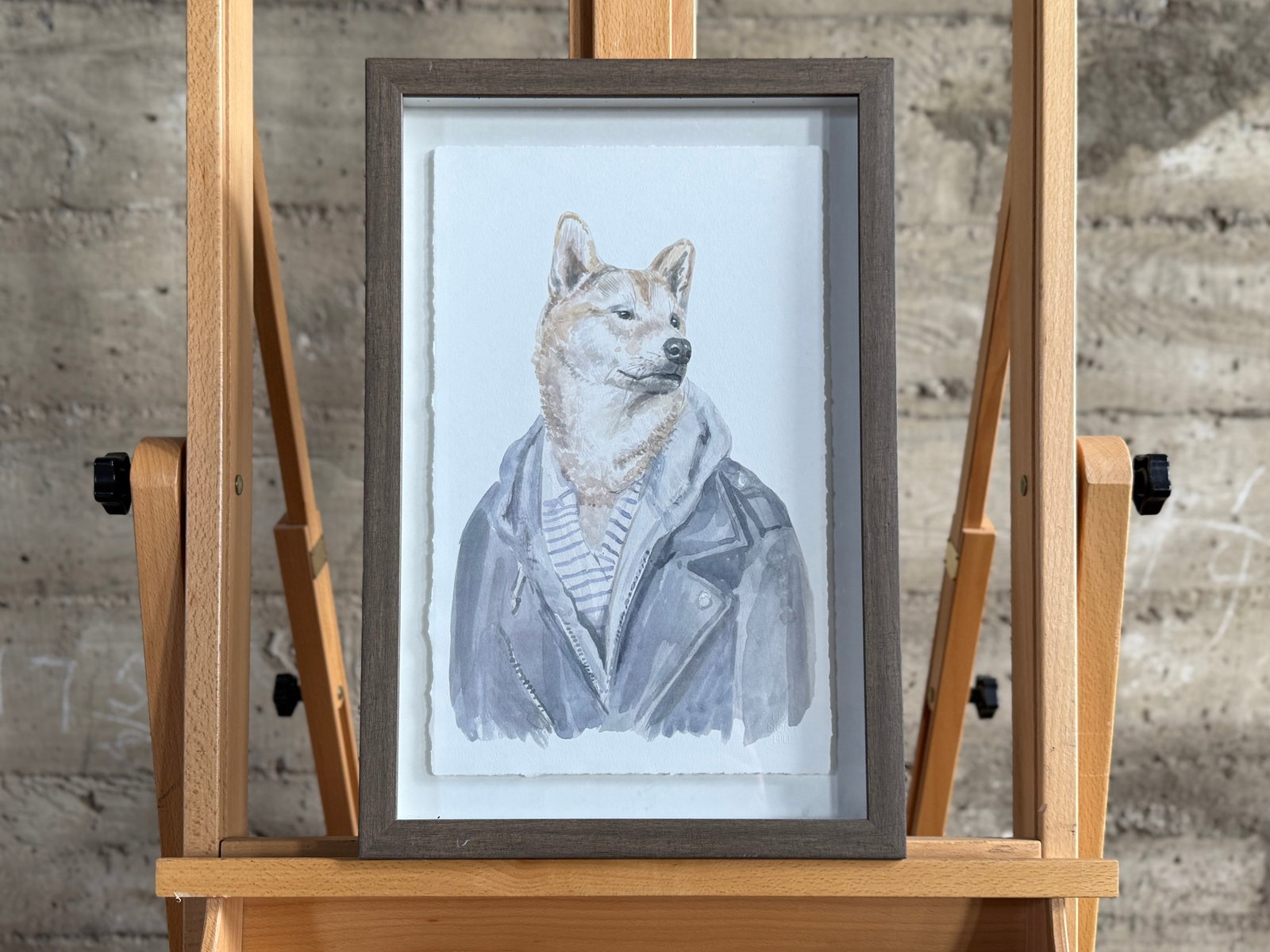 SHIBA INU DOG PRINT: This lot features a professionally framed print of a Shiba Inu dog dressed in a leather jacket. This piece measures in frame, 18'' H x 12'' W.