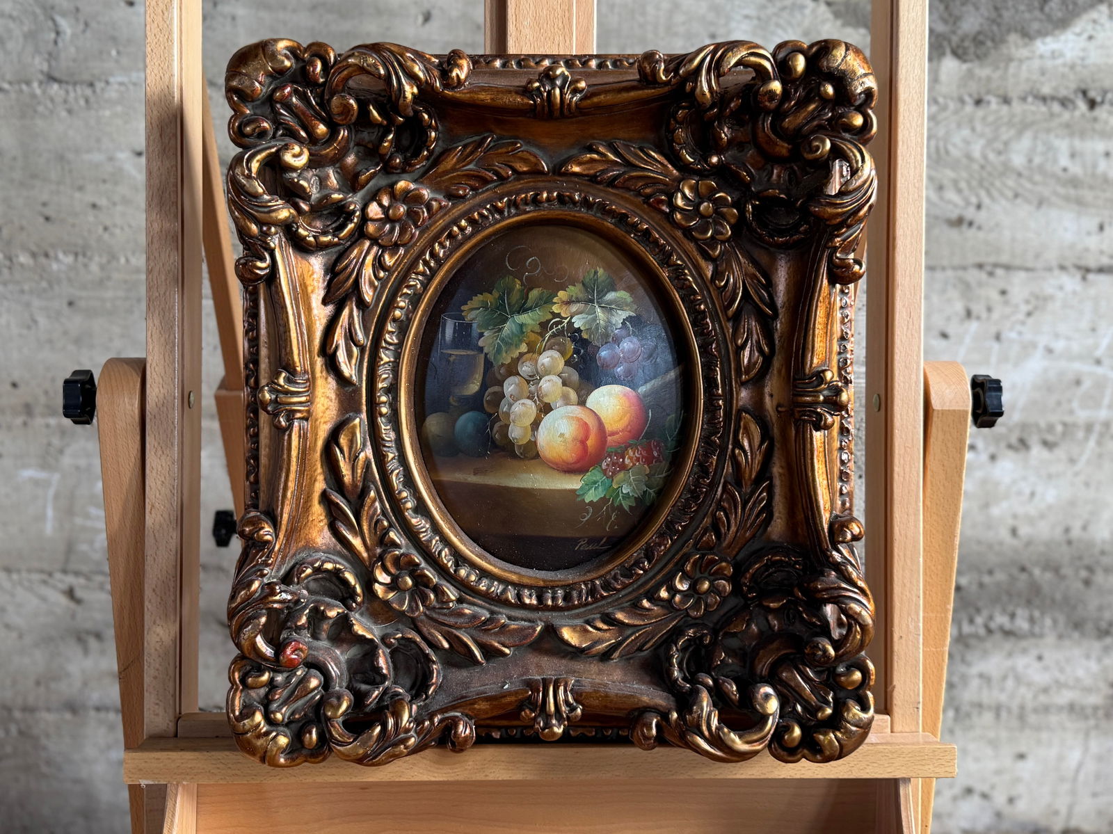 FRUIT STILL LIFE PAINTING IN FRAME: This lot features a fruit still life painting in frame with a signature lower right. This frame is a modern reproduction, but quite beautiful! This piece measures in frame, 18'' H x 16'' W.
