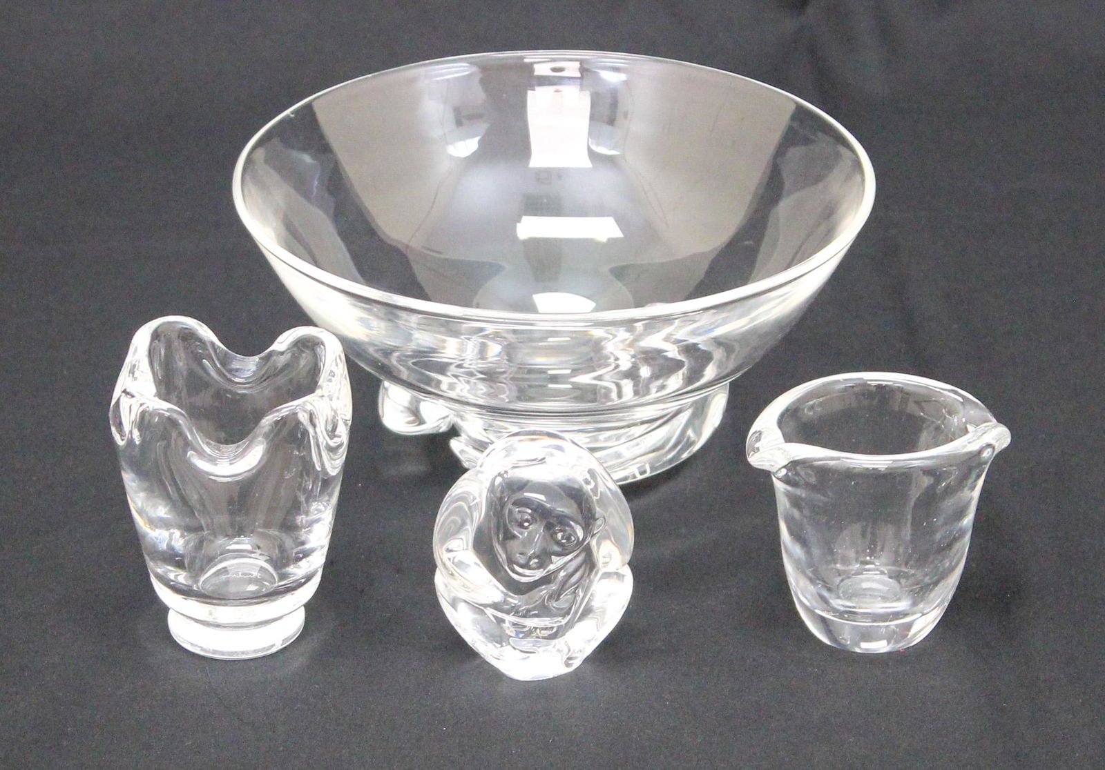 Group of (4) Assorted Steuben Crystal Items: Group of (4) assorted Steuben crystal items, spiral bowl, 3.5"h x 7"d, tooth picks/match holder, 3"h x 2.5"d, sauce cup/mini creamer, 2.5"h x 2.75"d, and paperweight/handcooler monkey, 2.75"h x 2.25"d