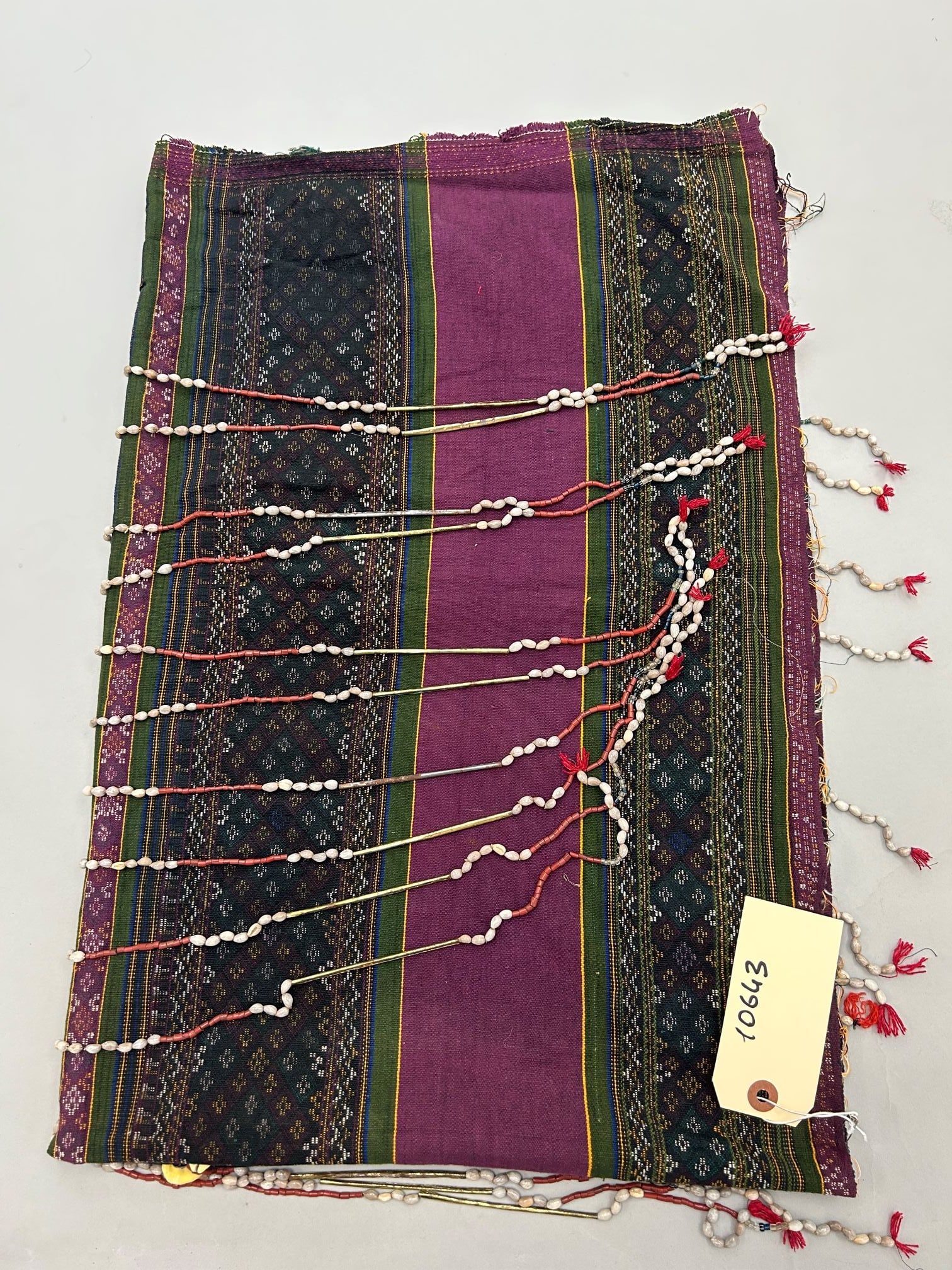 India, Nagaland, Ethnic Woven Cotton Skirt: India, Nagaland, ethnic woven cotton skirt with job's tear seeds, cawrie shells and metal tube beads, 32l"h x 50"w Provenance: From the estate of Dr. Philip Gould , New York