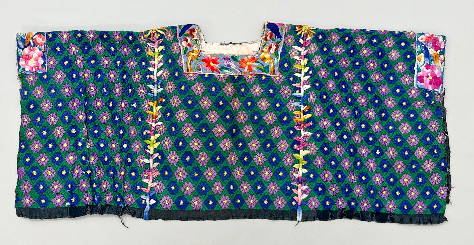 Coban/Tactic, Alta Perapaz Department, Guatemala, Vintage Woven Cotton "Huipil" Tunic: Coban/Tactic, Alta Perapaz Department, Guatemala, vintage woven cotton "Huipil" tunic with multicolor flower, bird and leaf garland, 15"l x 35"w PROVENANCE:From the estate of Professor Philip Gould, N