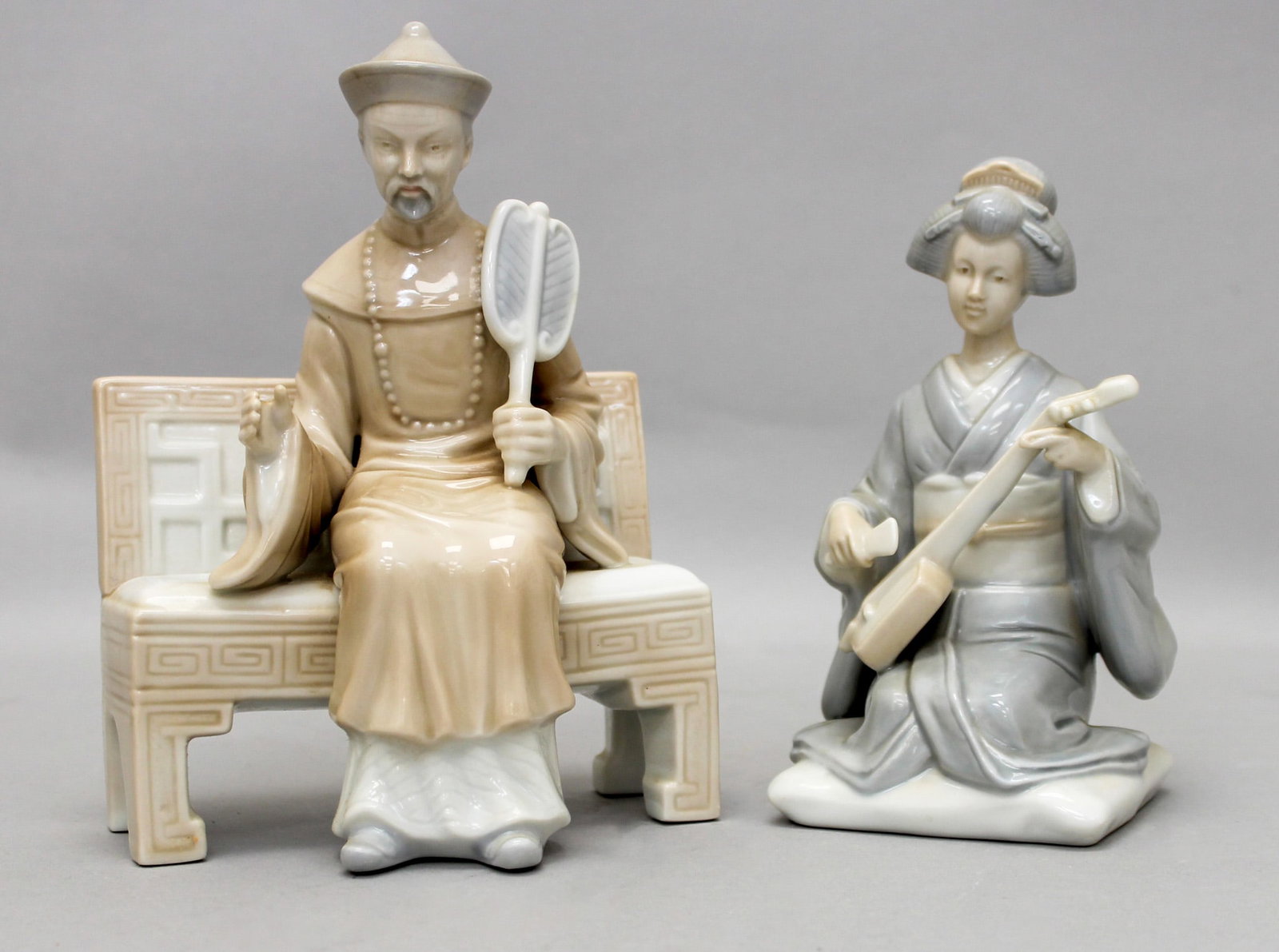Group of (2) Otagiri Japanese Porcelain Figurines: Group of (2) Otagiri Japanese porcelain figurines, man on bench with fan, label on bottom, 7"h x 5.25" x3.5"d, young geisha playing shamisen, 6.5"h x 3"w x 3.5"d, unmarked