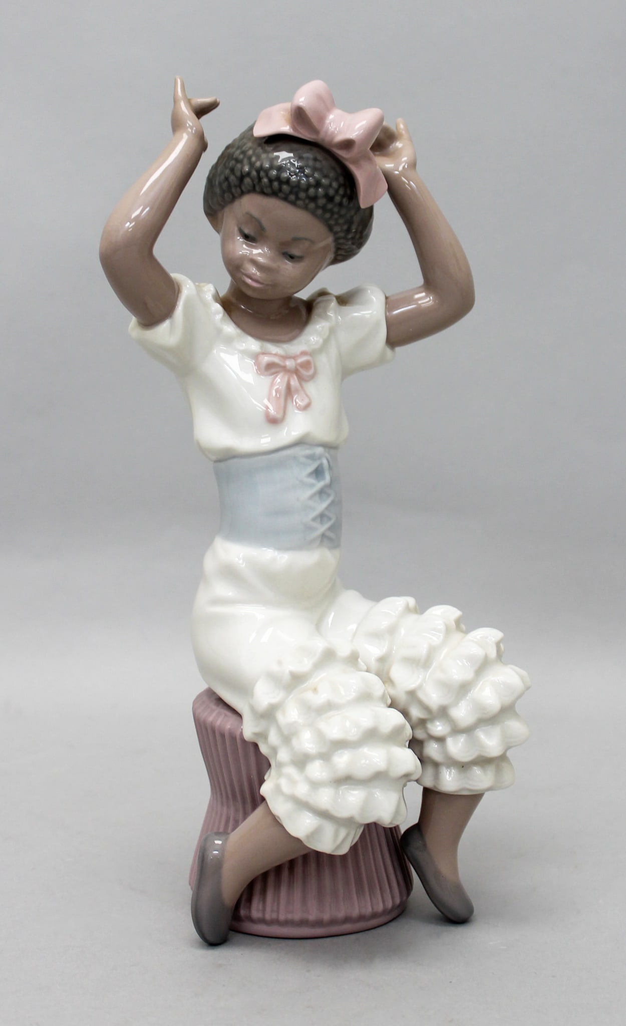 Lladro Figurine "Rhumba" 5160: Lladro figurine "Rhumba" 5160, seated girl in white outfit with pink bow on her head, mark on bottom Lladro Hand Made in Spain DAISA, retaired, 9"h x 3"w x 3"d