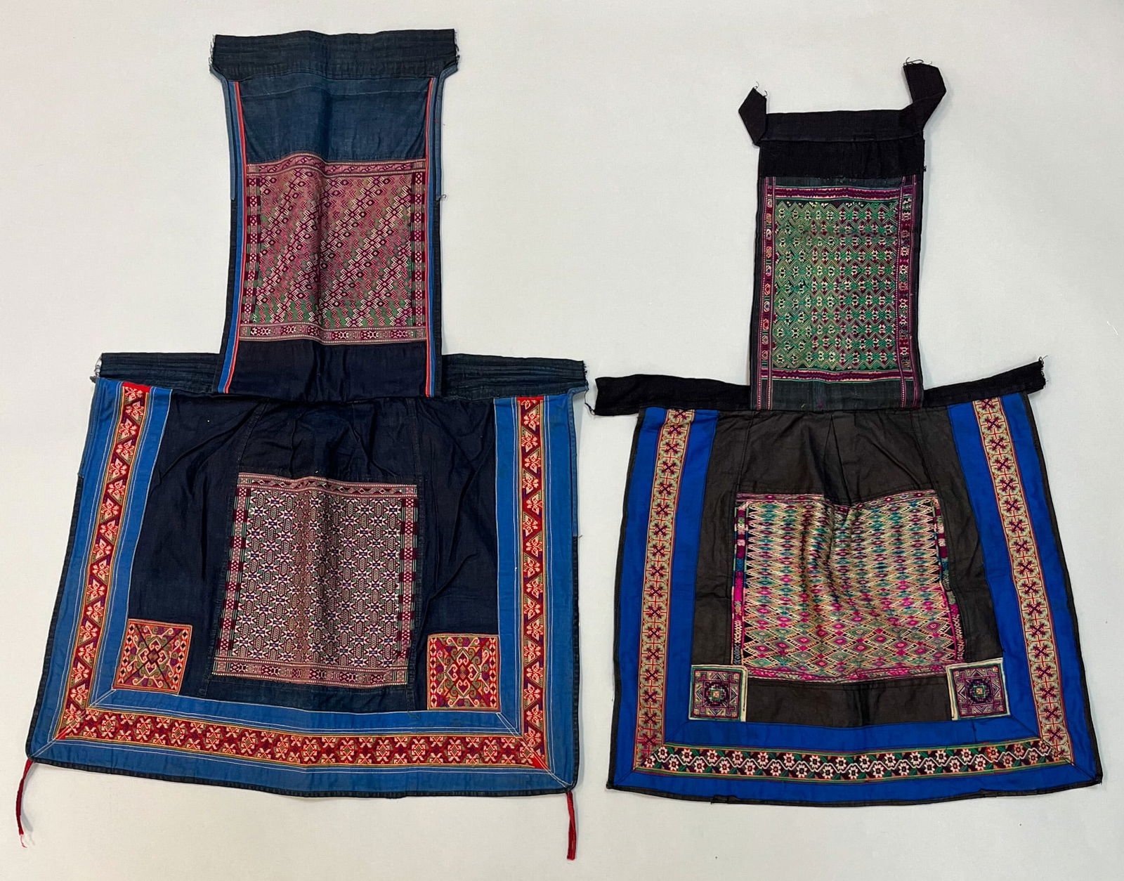 Hmong, Southeast China, Group of (2) Cotton and Silk Embroidery Baby Carriers: Hmong, Southeast China, group of (2) cotton and silk embroidery baby carriers, one in black color ground with predominantly green and fuchsia accents embroidery, 27"l x 17"w, one black ground with pin