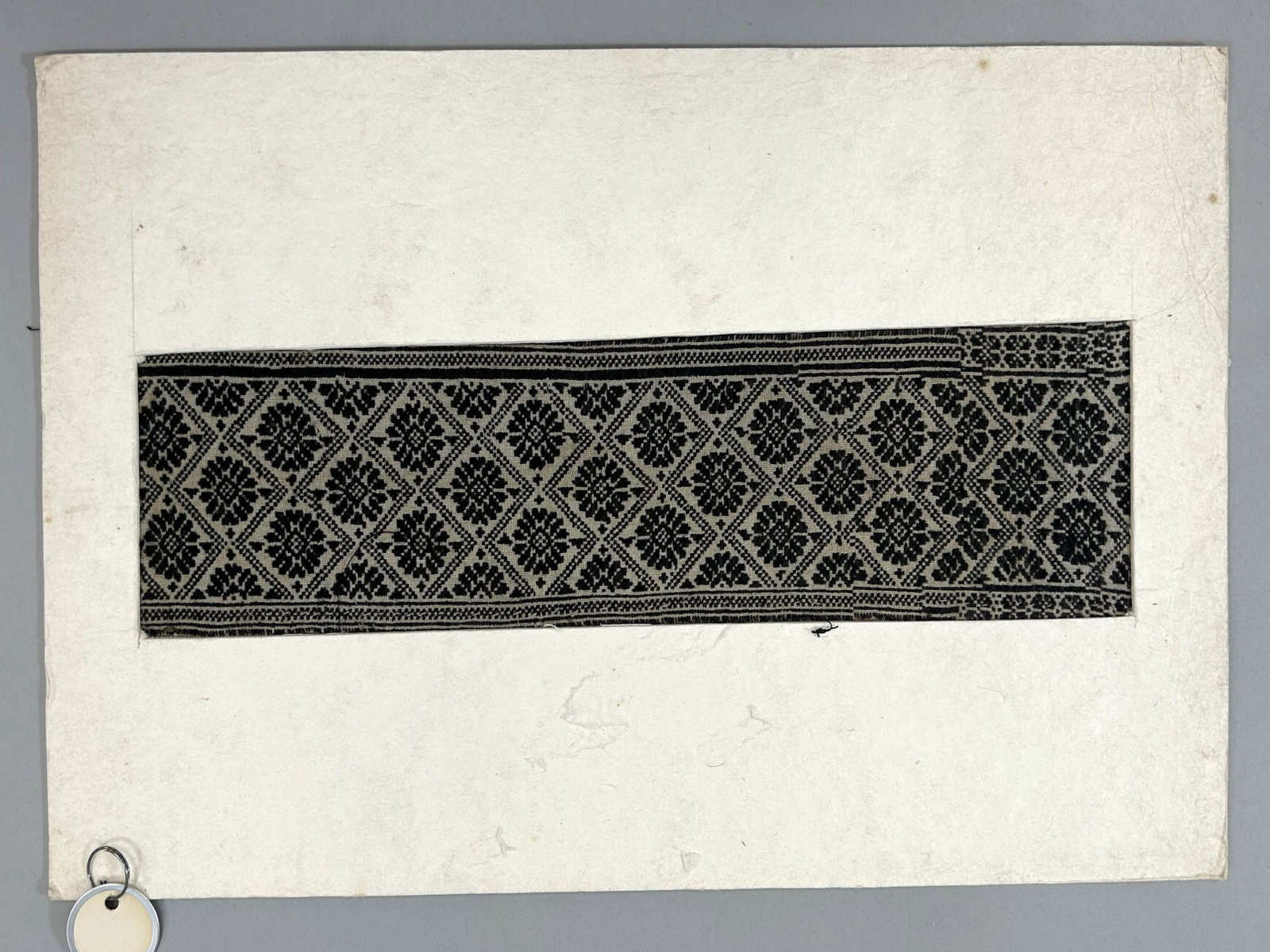 Taiwan Aboriginal Embroidered Matted Textile Fragment: Taiwan Aboriginal Embroidered Textile Fragment, possibly matted for exhibition, approximately 15"l x 5"w Provenance: From the estate of Dr. Philip Gould , New York