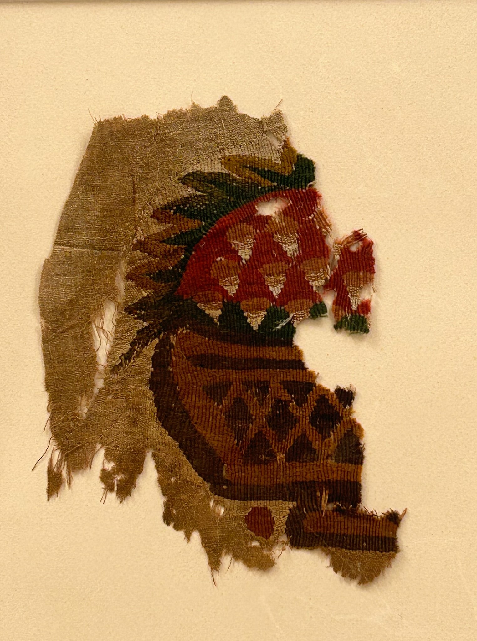 Coptic Textile Fragment: 3rd - 10th Century Coptic textile fragment, geometric design in red, green, brown and undyed fabric, Egypt, North Africa. Approximate size 8" x 6" . Matted. PROVENANCE:From the estate of Professor Phi
