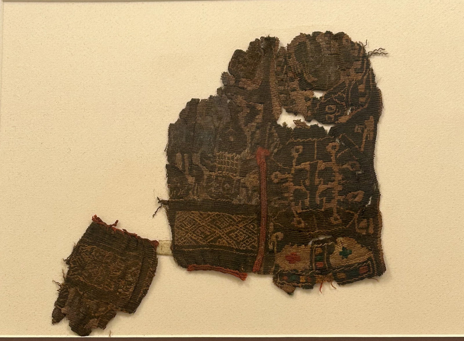 Coptic Textile Fragment: 3rd - 10th Century Coptic textile fragments, of complex geometric form, in red, green and brown, Egypt, North Africa. Approximate size 6.5" x 5". Matted. PROVENANCE:From the estate of Professor Philip