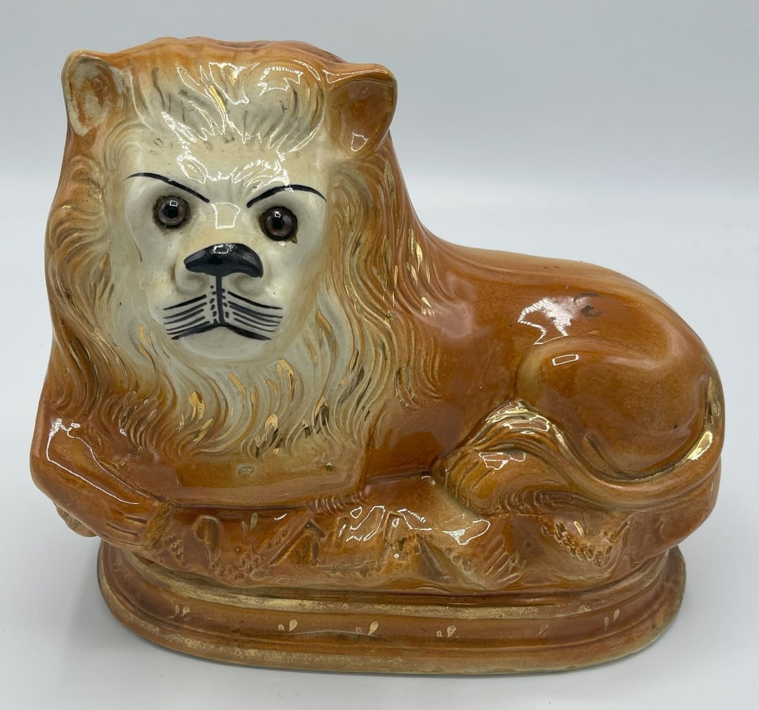 Porcelain Earthenware Staffordshire Lion: Porcelain Earthenware Staffordshire Lion. Hand painted with glass eyes. Measures approx. 10.75"l x 4.5"w x 9"h