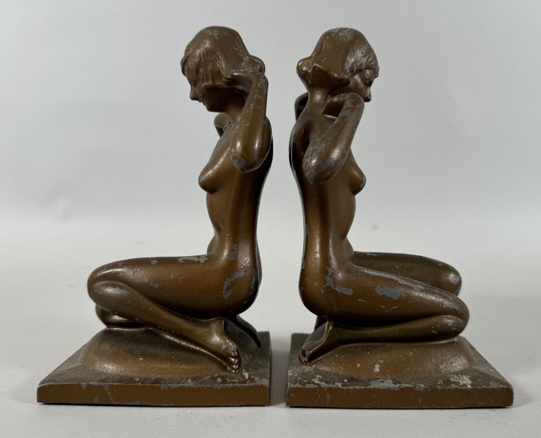 Vintage Pair of Nude Femal Book Ends: Vintage pair of bronzed nude female book ends. Bronzart copyright. Possibly made of pot metal. D: 6.75"h x 3"w x 4"d.