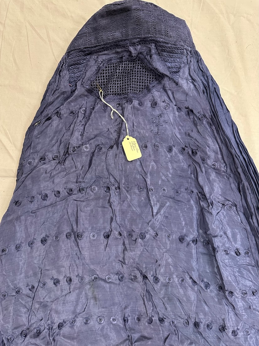 Vintage Silk Afghan Burqa Garment: Silk Afghan burqa made out of periwinkle blue fabric with pleating around back and embroidery includes floral shapes below the mesh opening for eyes. D: 29" x 59".