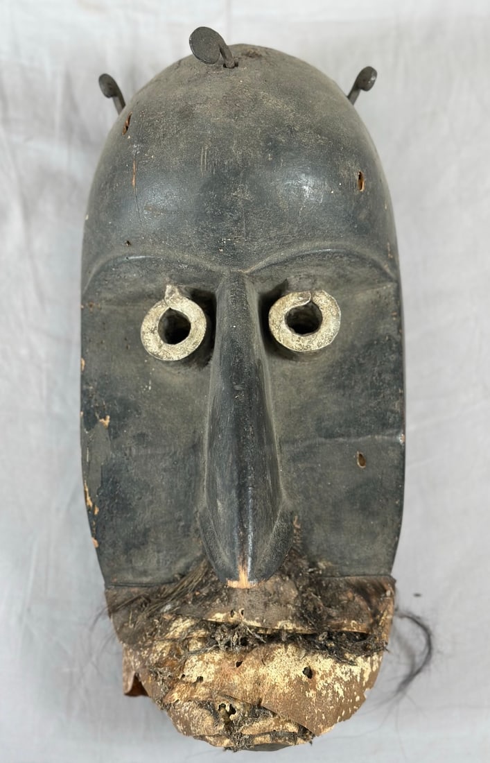 Toma Peoples Mask: Carved wood mask, with metal and organic materials, Toma peoples, Republic of Liberia or Republic of Guinea, West Africa. Approx. 12" x 6" x 5"