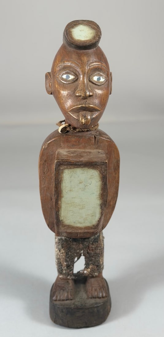 Nkisi Power Figure: An Nkisi style power figure, carved wood with glass, reptile skin, textile and organic matter, Democratic Republic of the Congo, Central Africa. Approx. 20" x 6" x 5"