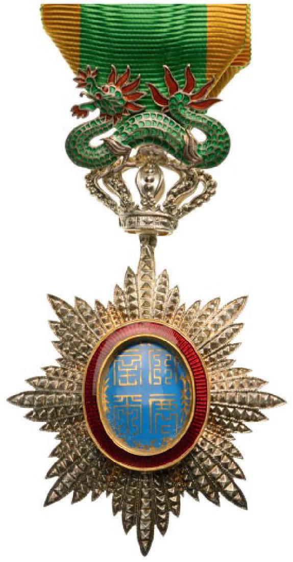 ORDER OF THE DRAGON OF ANNAM: Knight ‘s Cross, 5th Class, instituted in 1886. Breast Badge, Silver, brilliant cut rays, 89x50 mm, central medallion silver enameled, original suspension device, ring and ribbon. Mint quality! I