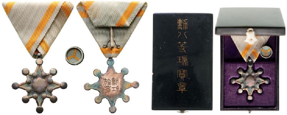 ORDER OF THE SACRED TREASURE (Kunnito zuihisho): 8th Class Badge, instituted in 1888. Breast Badge, 37 mm, Silver, reverse with Japanese inscriptions, original suspension ring and triangular ribbon, with lapel hole rosette and original lacquered box