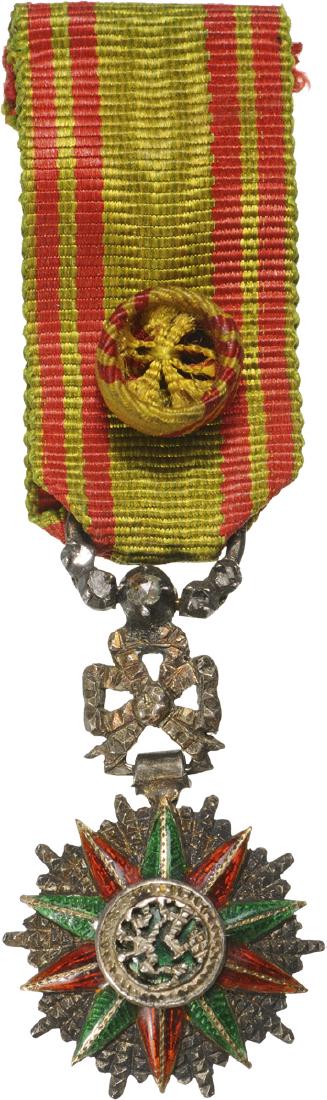 ORDER OF NICHAN AL IFTIKHARÂ : Officer's Cross Miniature, 4th Class. Breast Badge, 24x15 mm, Silver with brilliant cut rays, central medallion silver, enameled, original ornamented suspension device and ribbon with rosette. Beautif