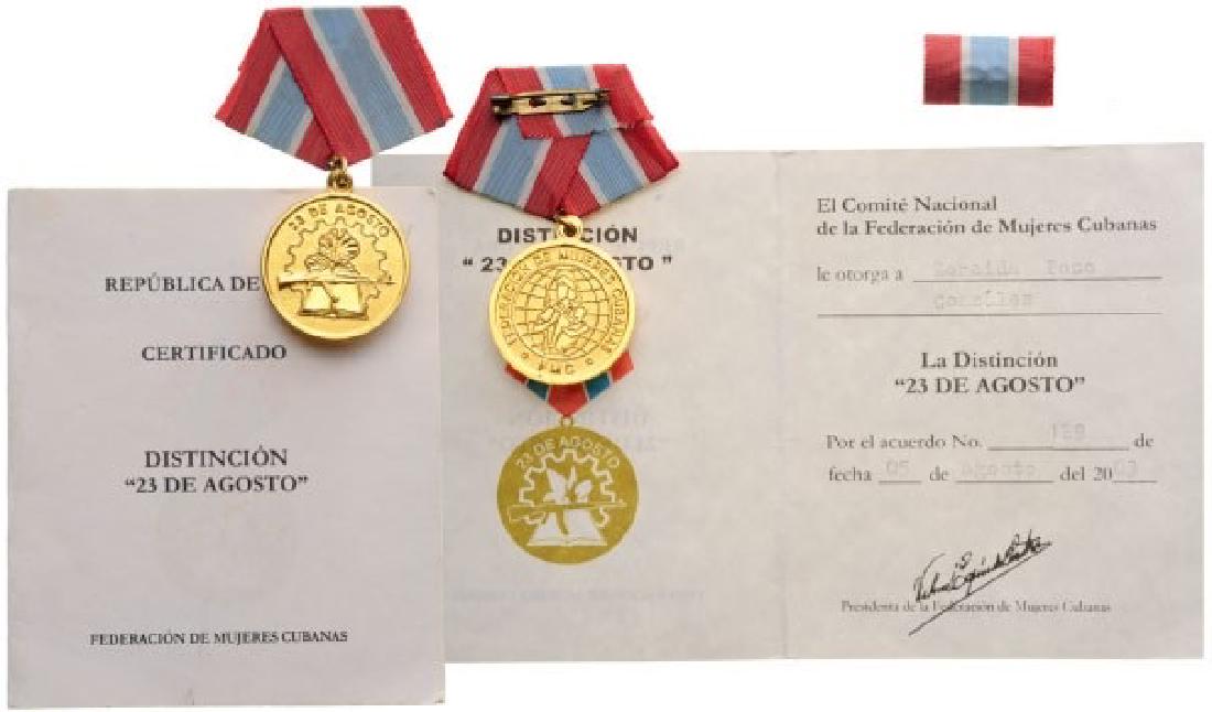 Cuban Federation of Women Medal for the 23rd of August: Breast Badge, 30 mm, gilt Bronze, original suspension ring and ribbon with ribbon bar. Comes with awarding document given in 1985 to a Cuban citizen. I