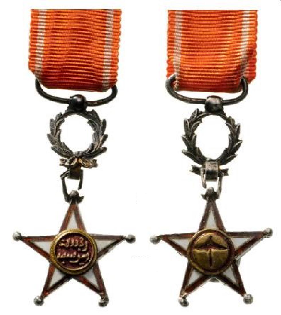 ORDER OF THE OUISSAM ALAOUITE: Miniature. Breast Badge, gilt Silver (2 balls slightly bent), 14 mm, enameled (crack), original suspension ring and ribbon. IIÂ