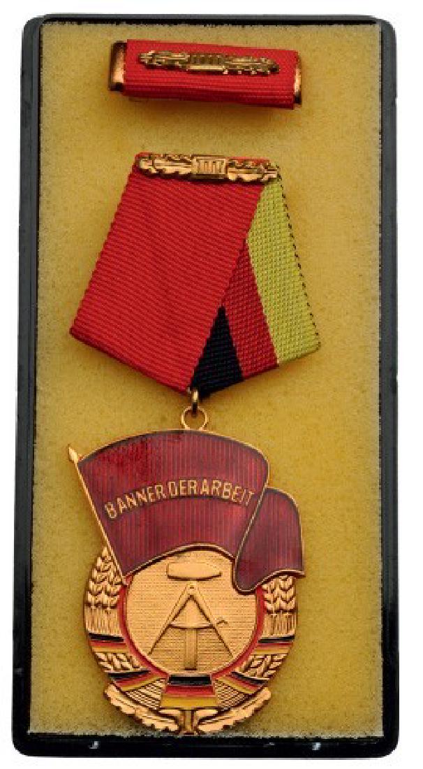 ORDER OF BANNER OF LABOR: 3rd Class, instituted in 1974. Breast Badge, gilt bronze, 48x36 mm, obverse enameled, original suspension ring and ribbon, with ribbon bar, in box of issue. I