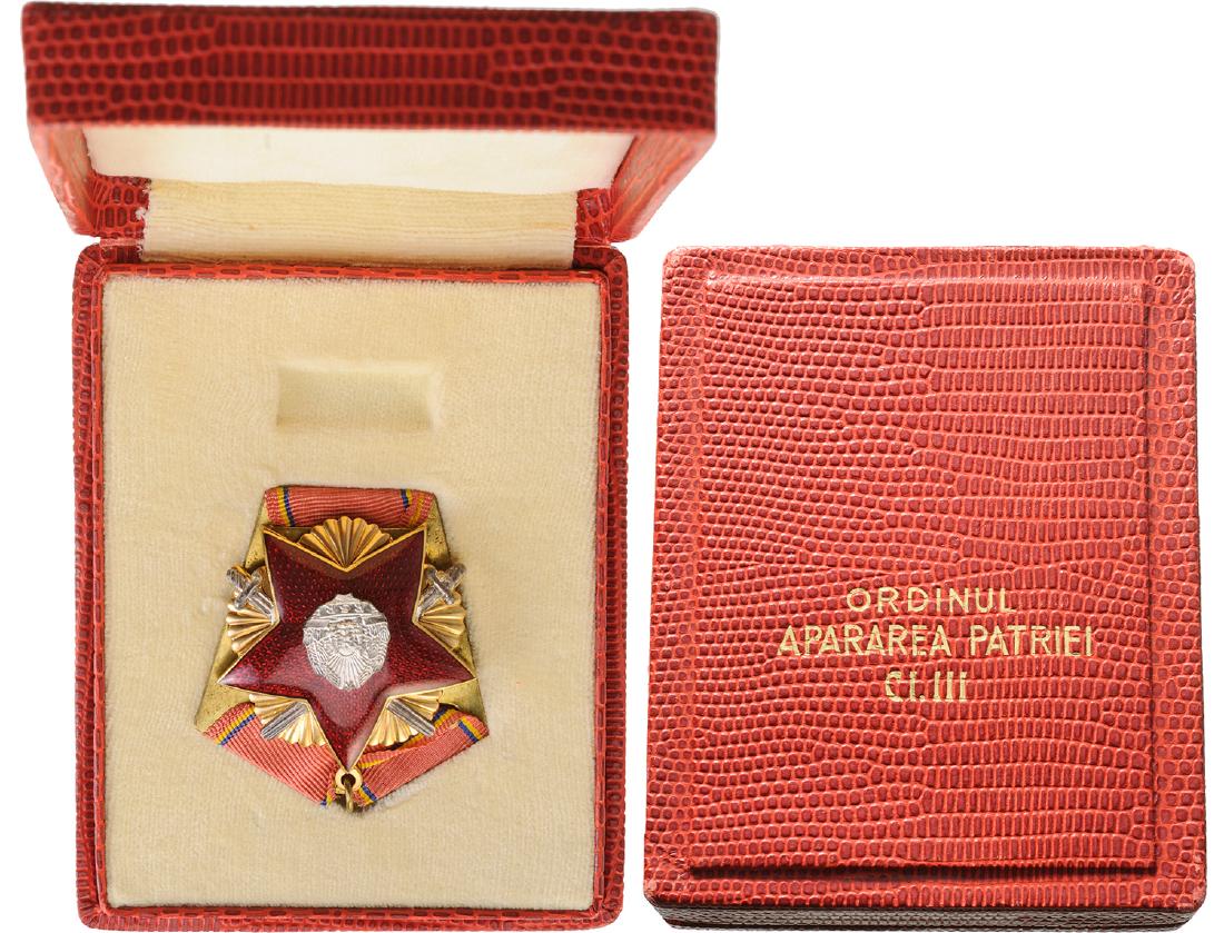 RSR - ORDER FOR DEFENCE OF THE FATHERLAND, instituted: ROMANIA - SOCIALIST REPUBLIC, 1966-1989, 3rd Class, 2nd Model. Breast Badge, 46 mm, gilt, original suspension ring and triangular ribbon, in rare original case of issue with gilt inscription on the li